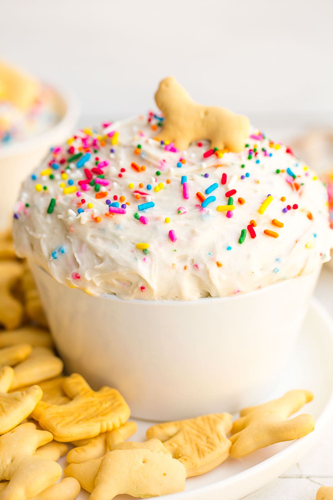 a big bowl of dunkaroo dip with sprinkles and an animal cracker on top