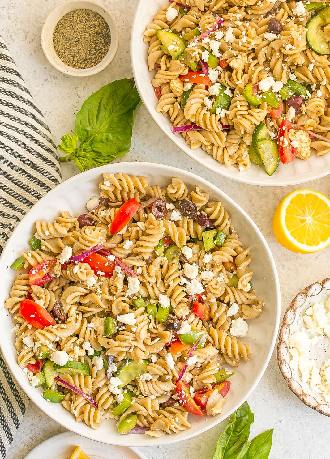 Two bowls filled with pasta salad.
