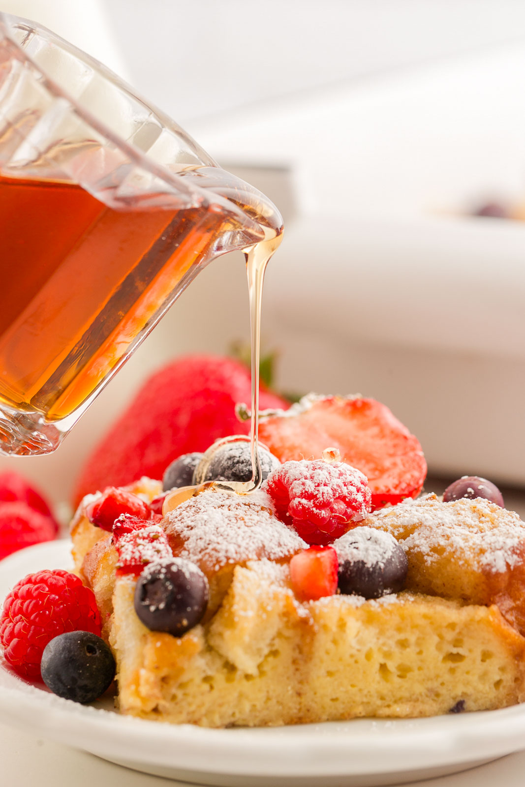 Hawaiian Roll French Toast Bake with maple syrup being poured on top.