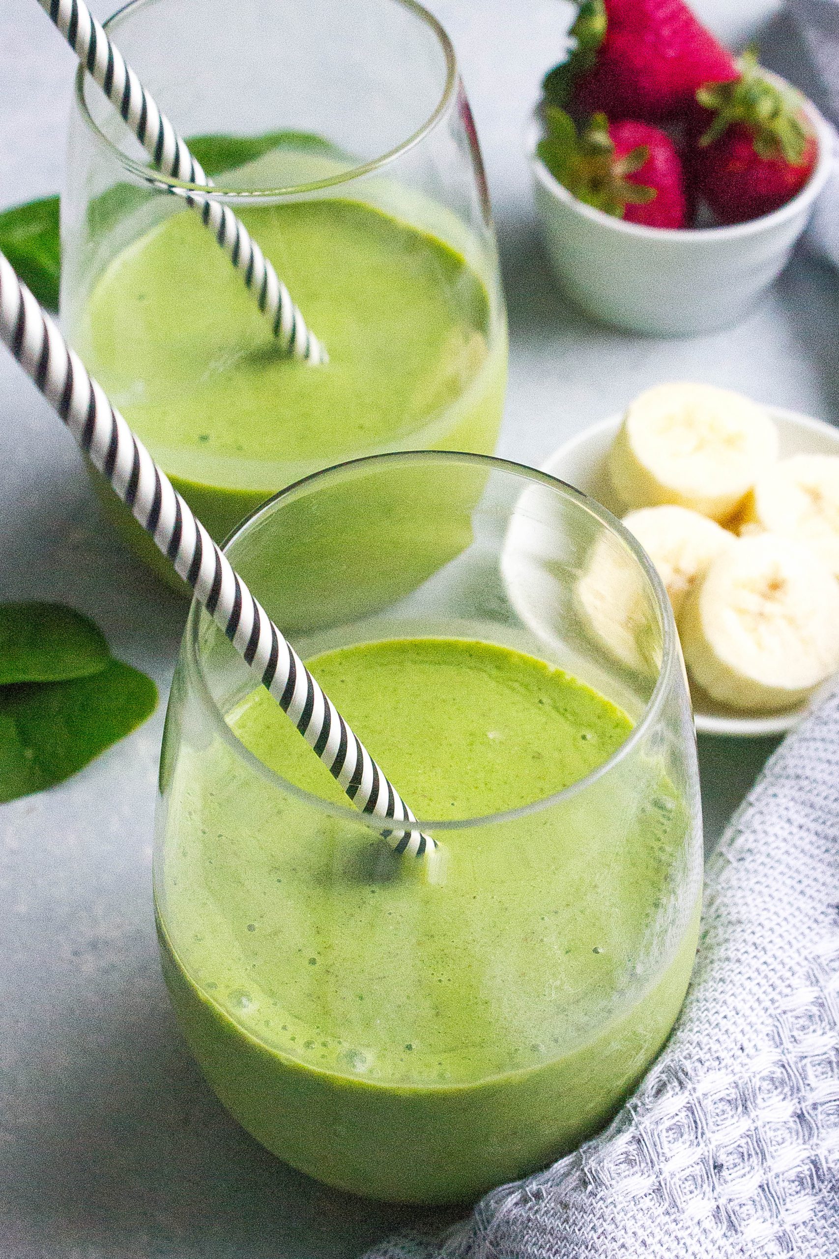 green detox smoothies with black and white straws
