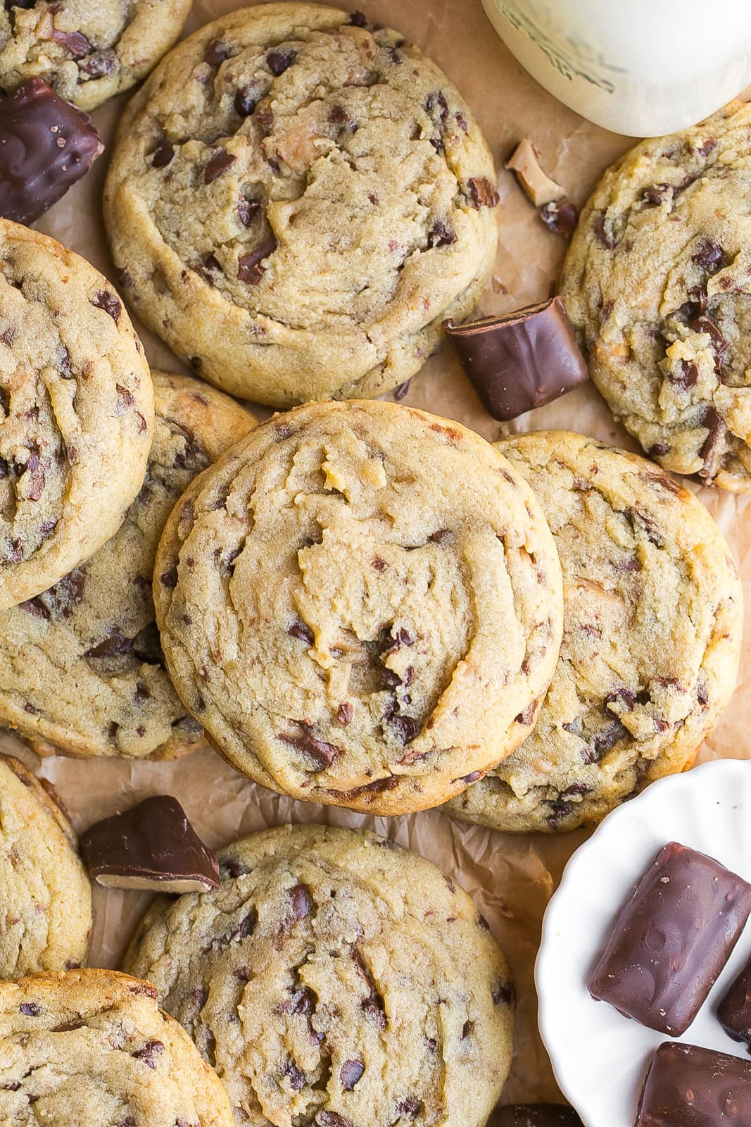 Toffee Chip Cookies on parchment paper with mini Heath bars.