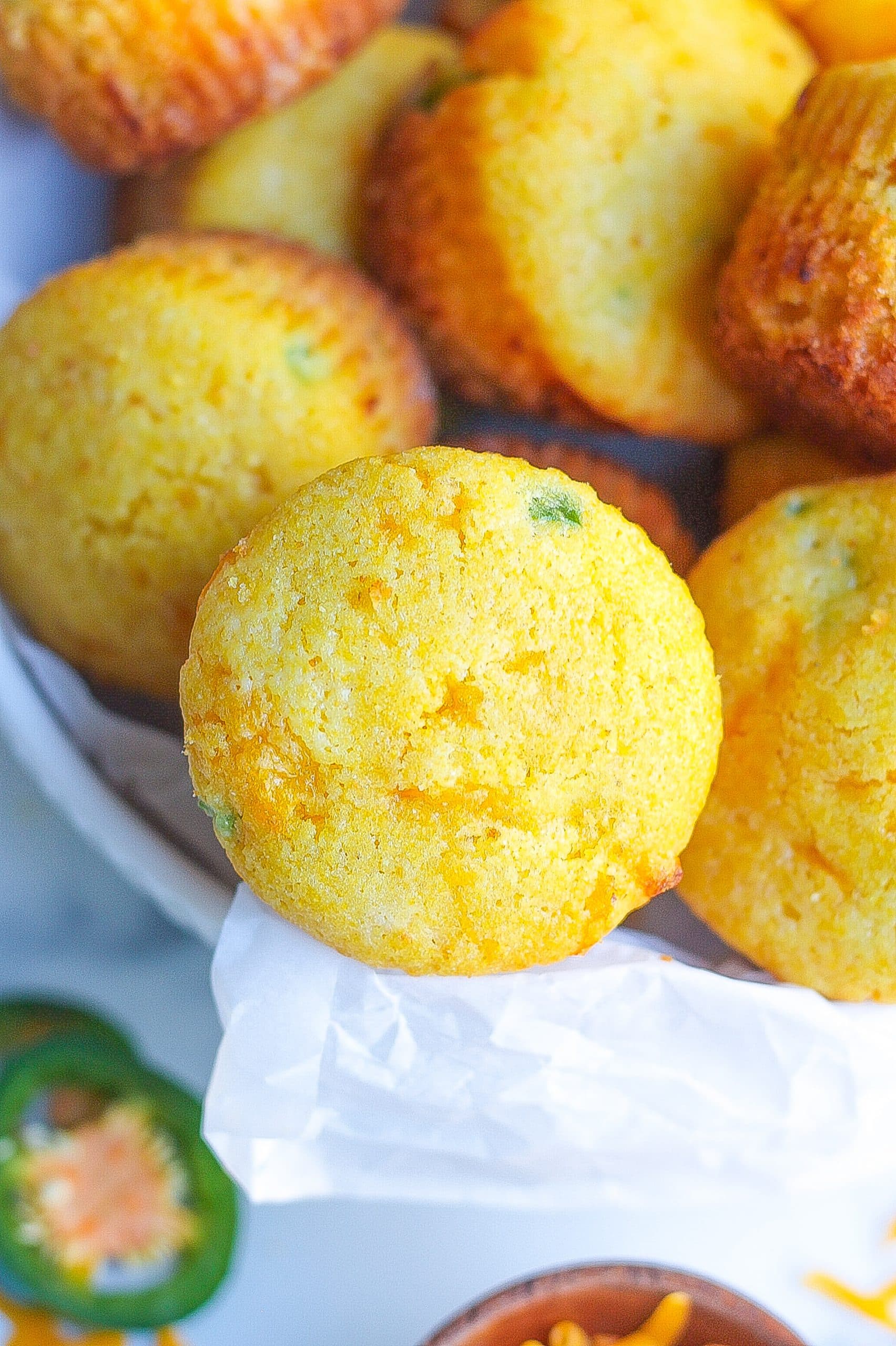 close view of bowl filled with cheddar cornbread muffins with jalapeño slices