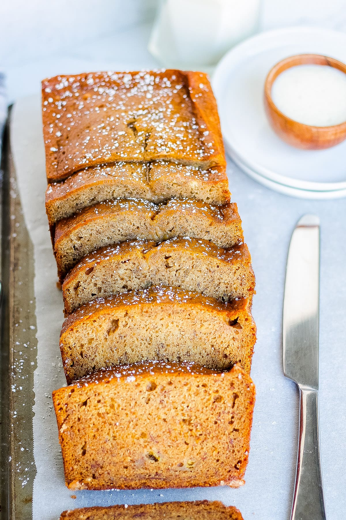 one sliced loaf of banana bread with cinnamon and powdered sugar