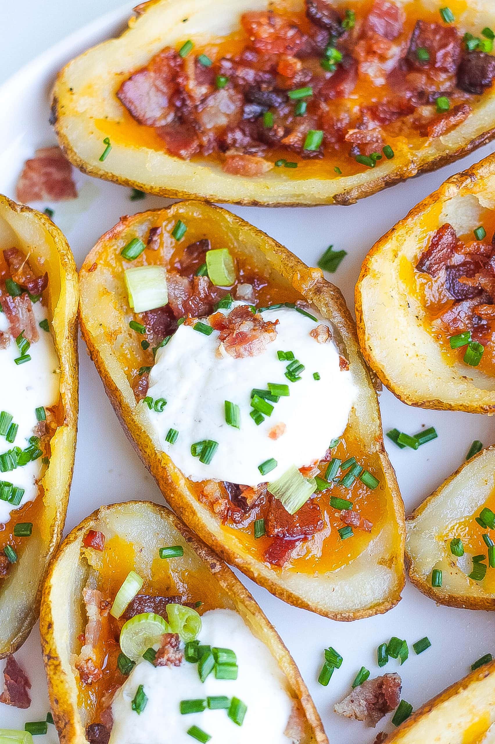 loaded potato skins with cheese, bacon, sour cream and chives