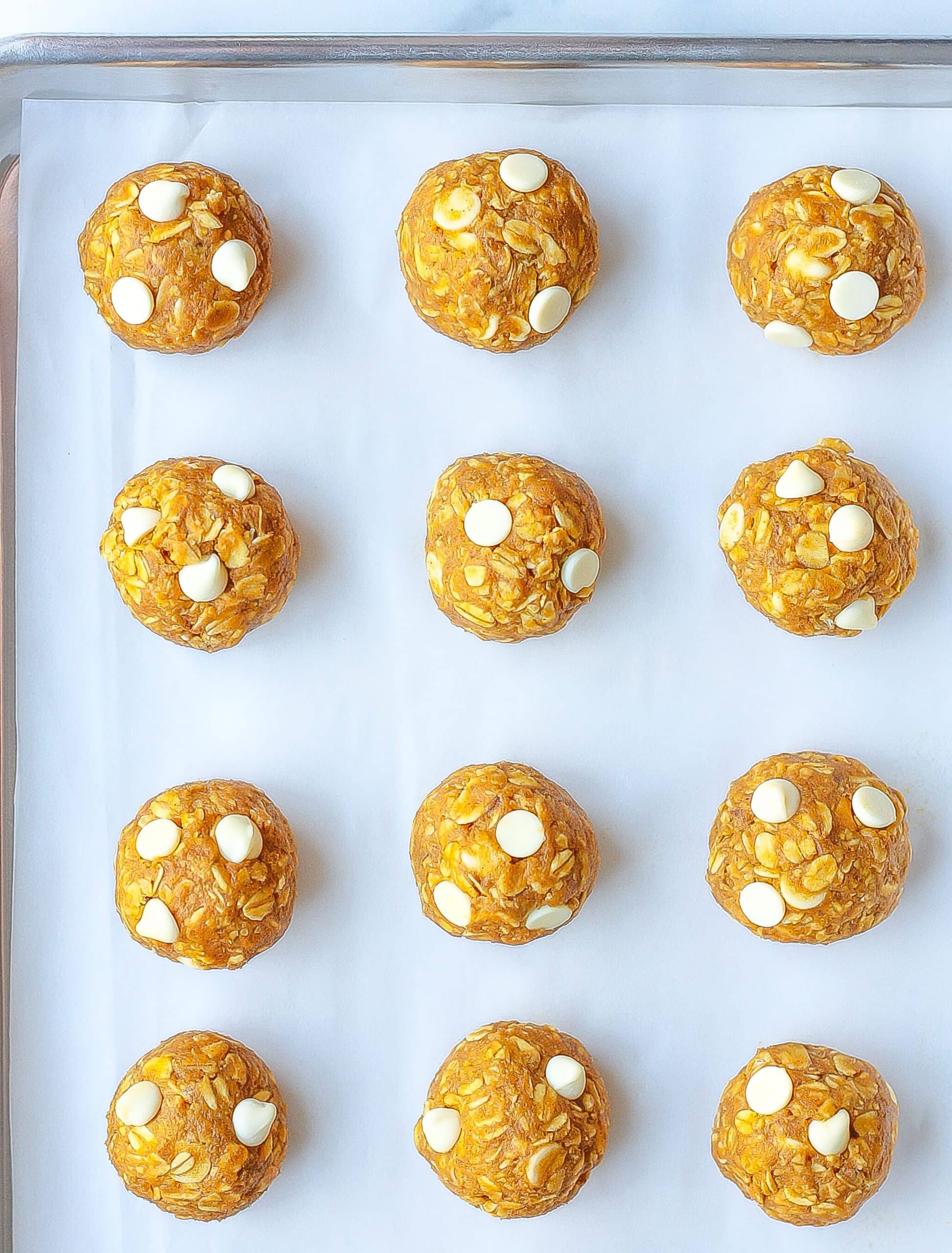 rows of pumpkin energy bites on baking sheet with parchment paper