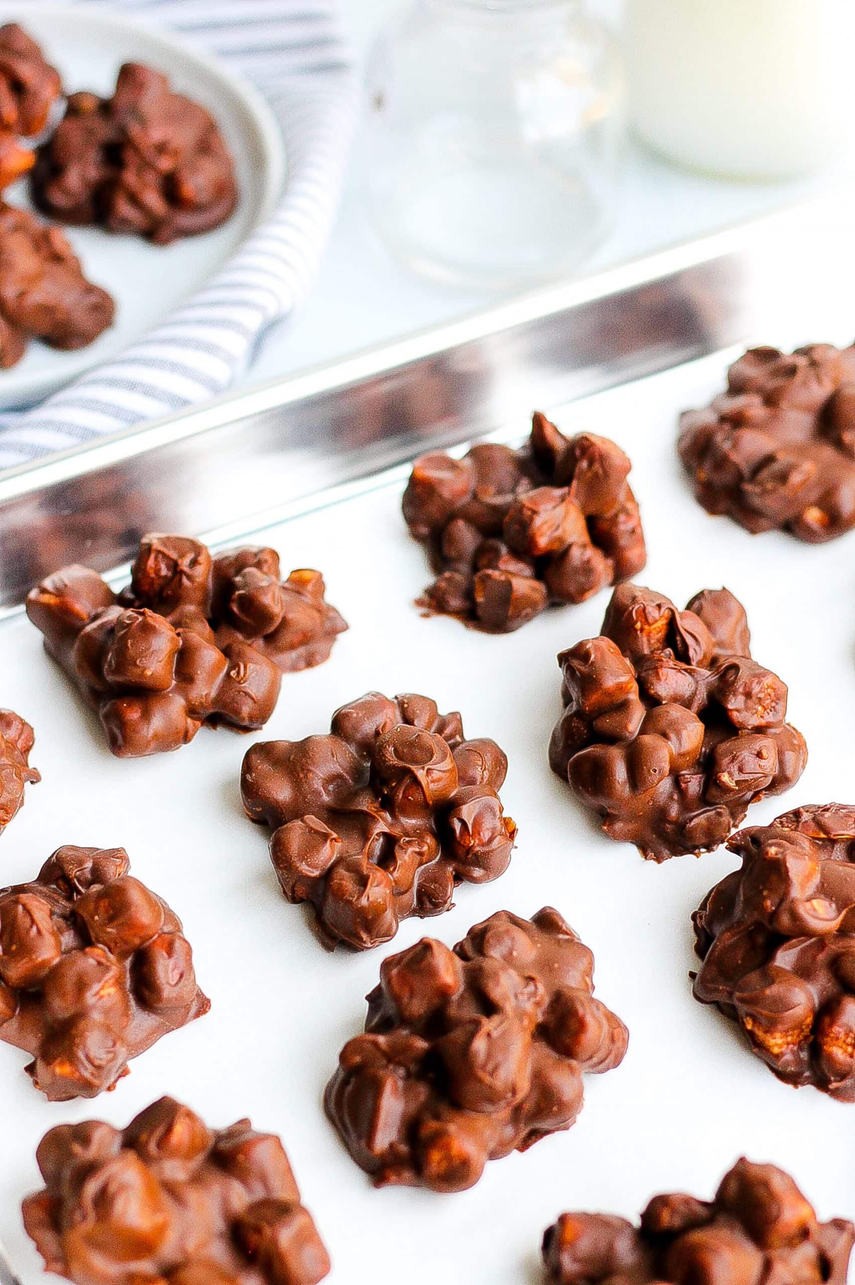 rocky road chocolate candy clusters on parchment paper and baking sheet