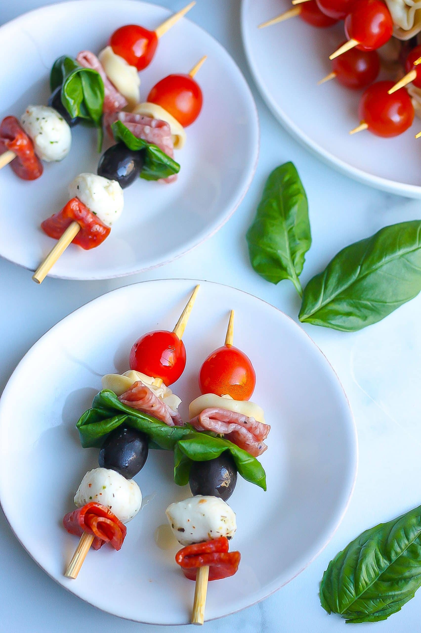 bite size antipasto skewers on small white plates