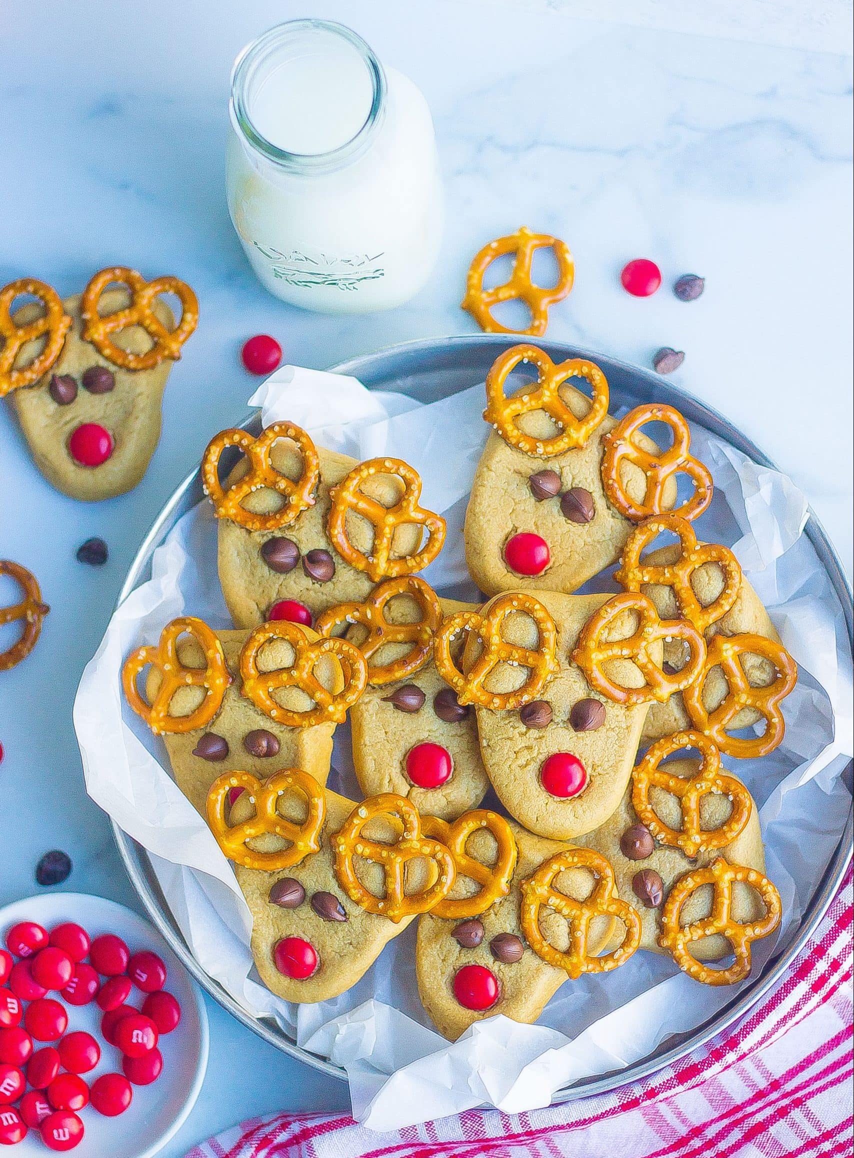 reindeer cookies layered on a serving dish but a glass of milk