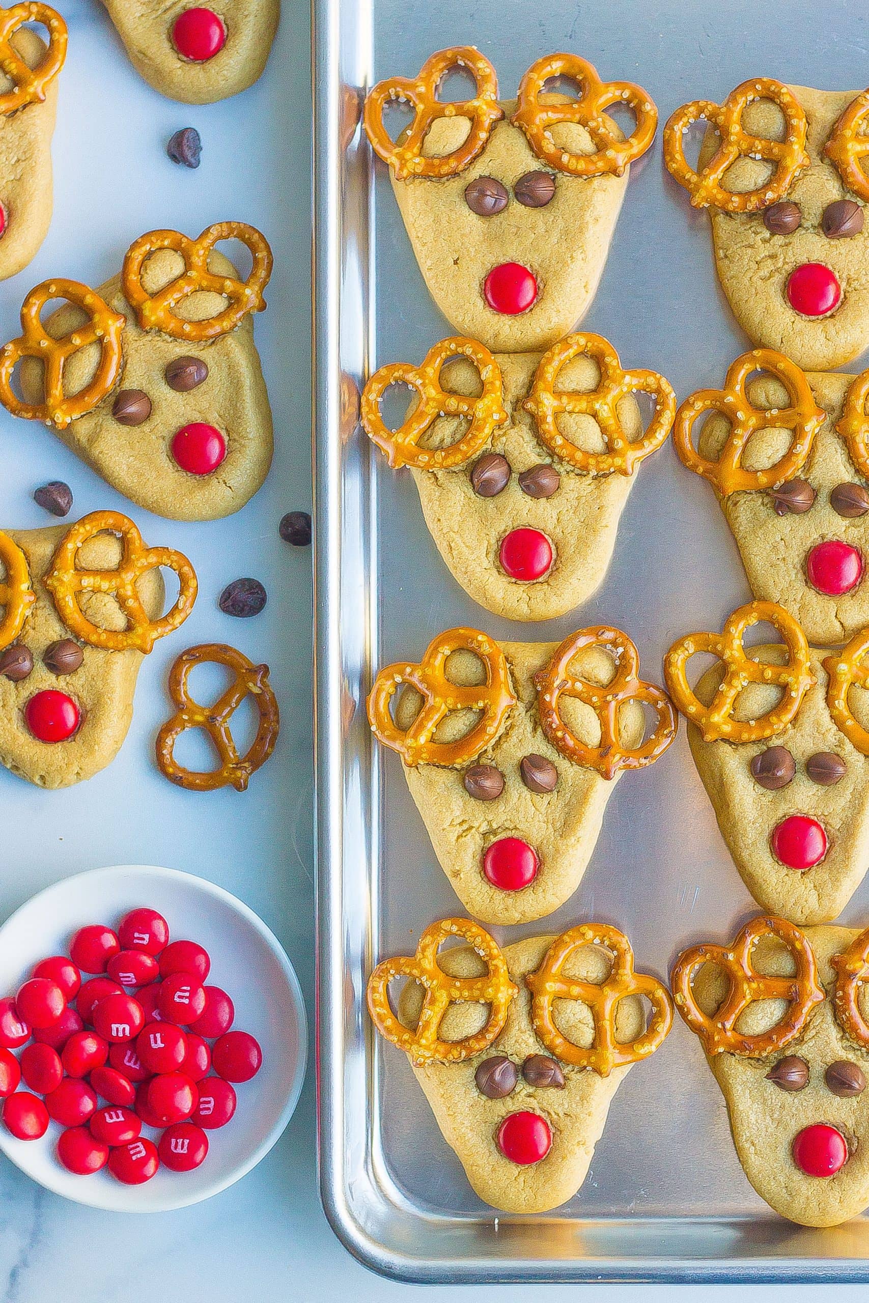 Reindeer cookies on table and baking sheet