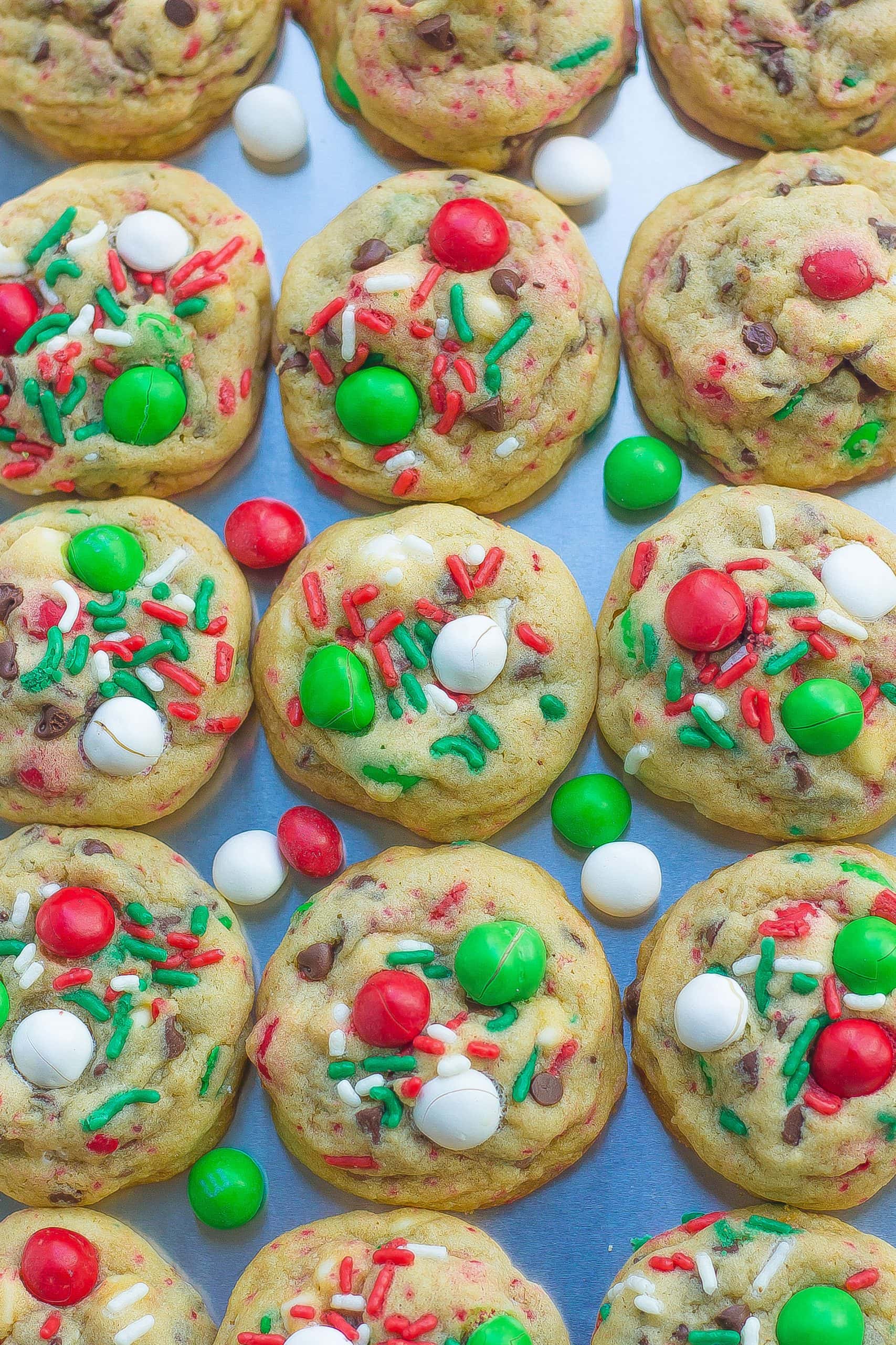 top view of baked Santa cookies on tray with M&Ms and sprinkles