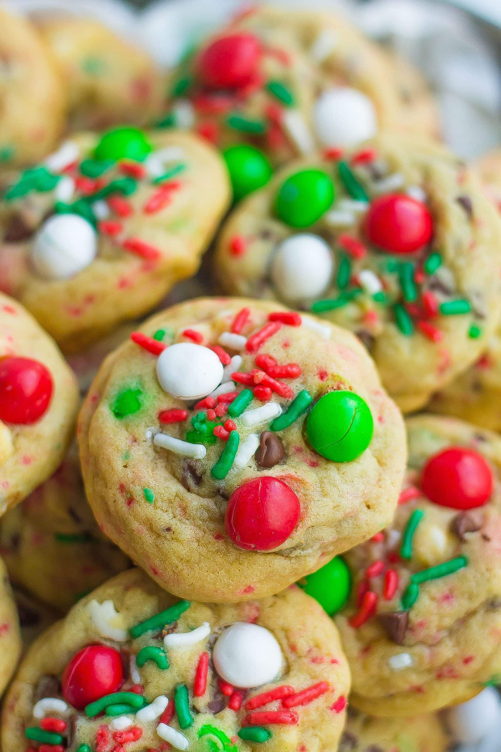 close image of baked Santa cookies with sprinkles, Christmas M&Ms, and chocolate chips