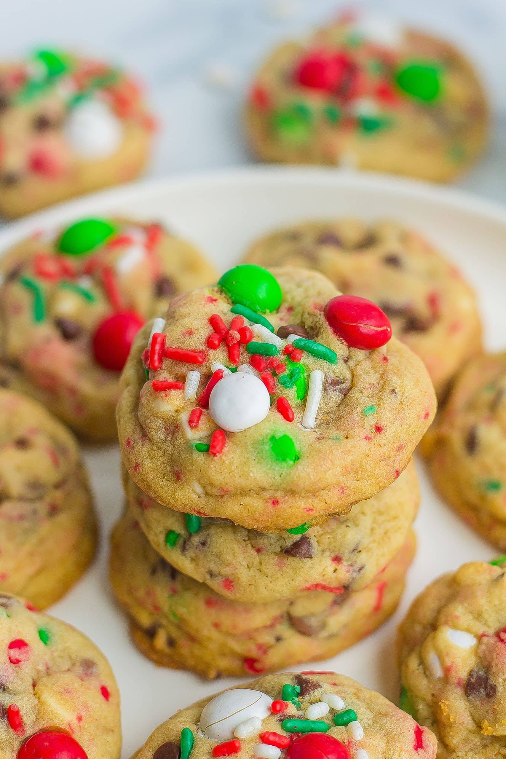 one stack of Santa cookies on white plate with M&Ms, sprinkles, and chocolate chips
