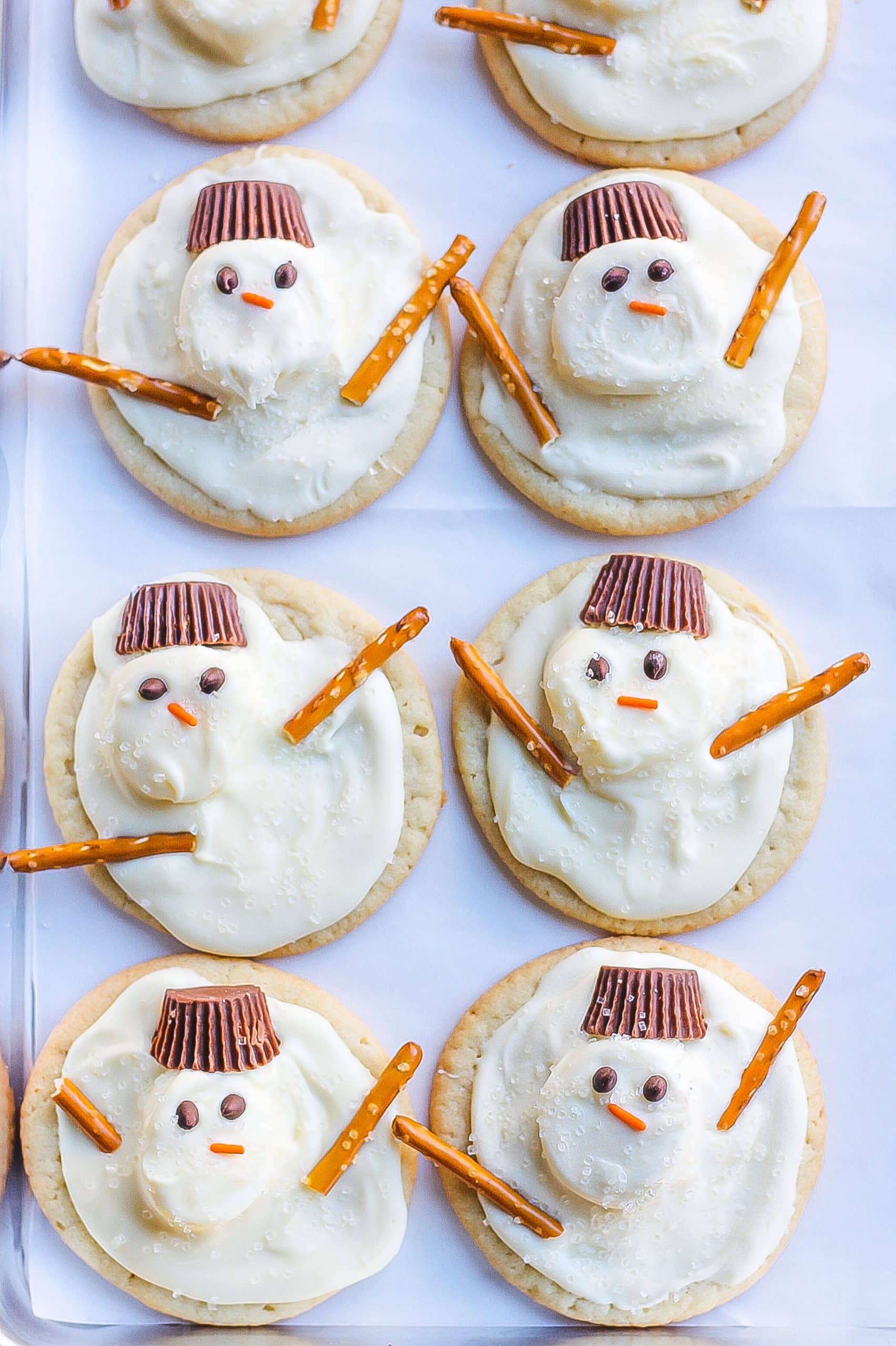 eight melted snowman cookies on white surface 