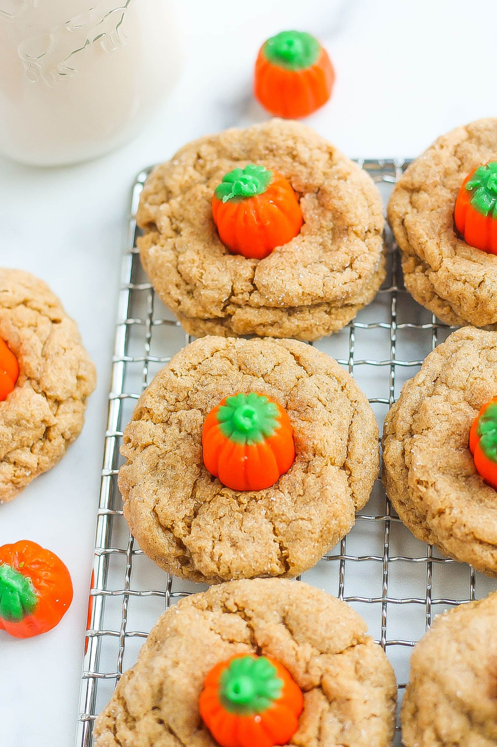 baked spice cookies with pumpkin candies on a wire wrack. 