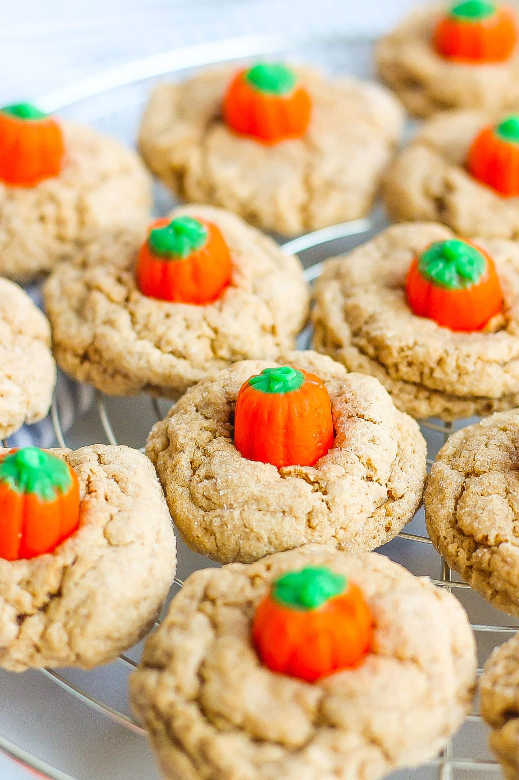 Spice cake mix cookies with pumpkin candies on wire rack. 