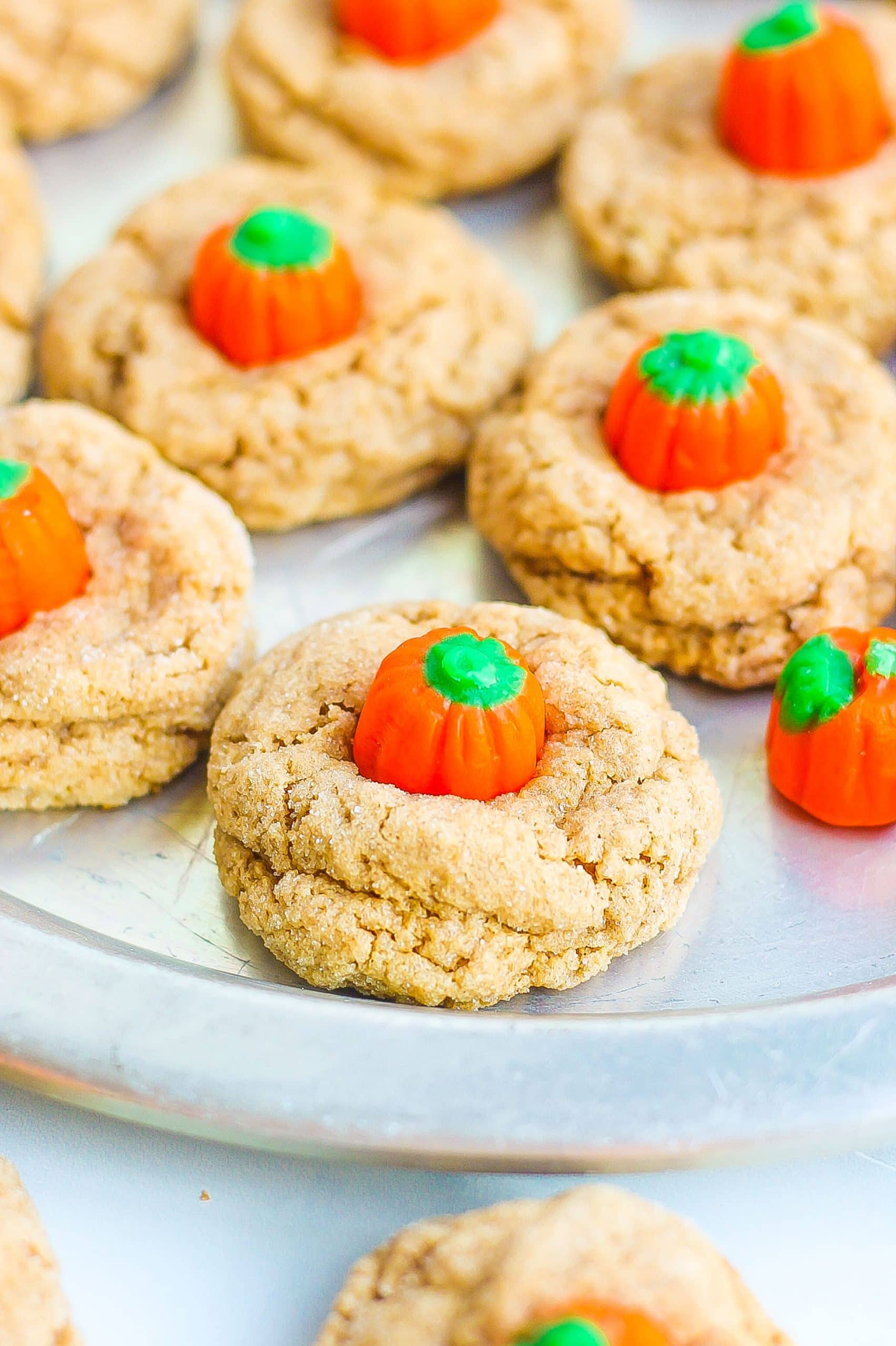 Spice cookies with pumpkin candy on silver serving dish. 