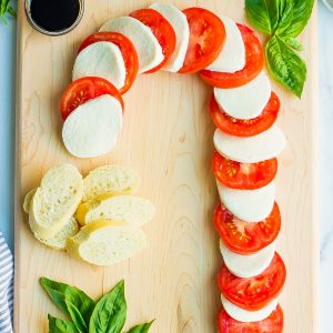 candy cane caprese with bread, basil, and balsamic on wooden board