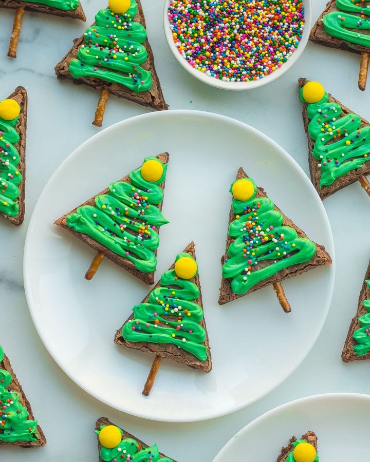 Overhead close-up of 3 christmas tree brownies on a circular white plate.