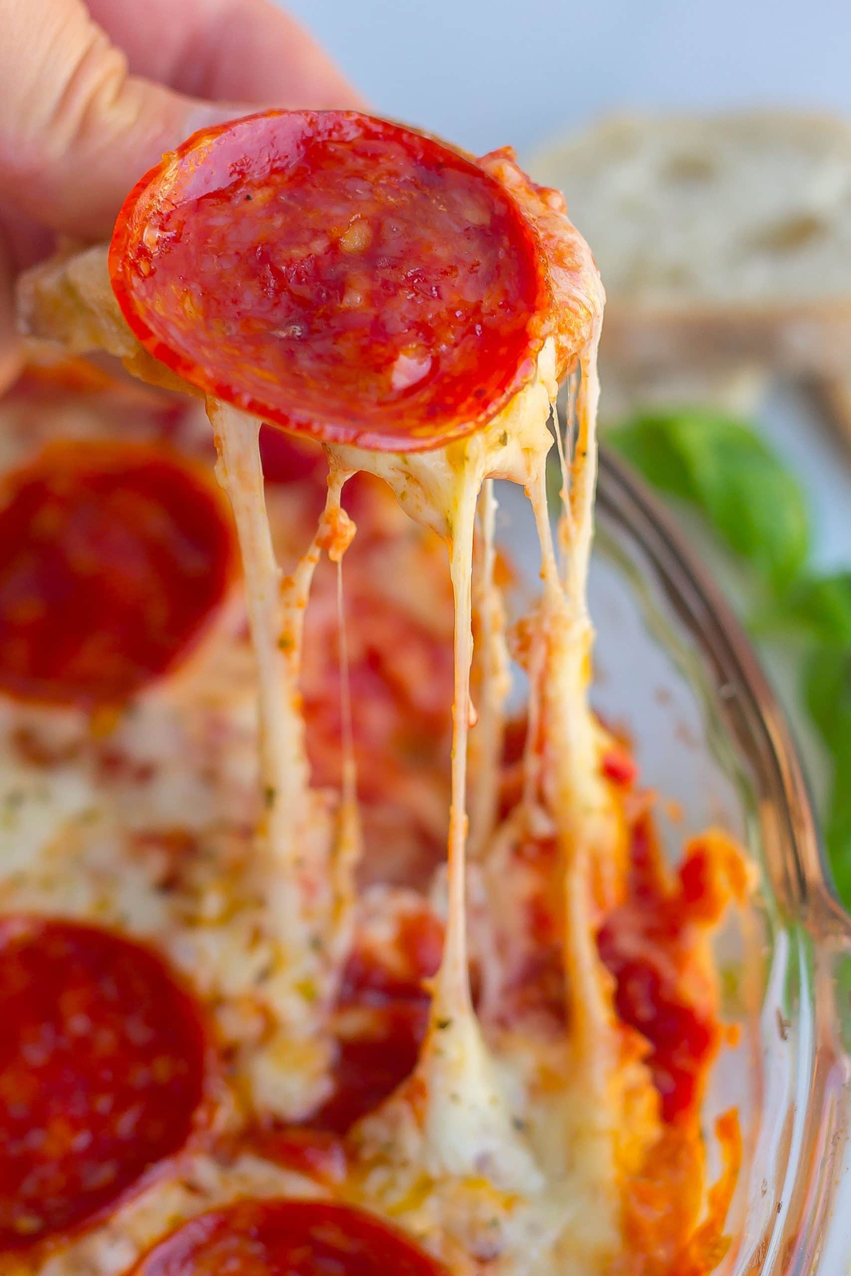 one pepperoni with gooey strings of melted cheese from the baked dip 
