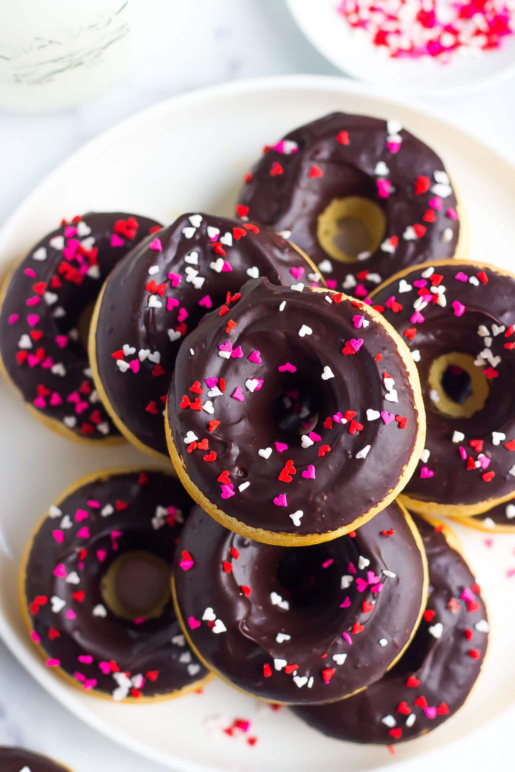baked donuts on plate with chocolate icing and sprinkles
