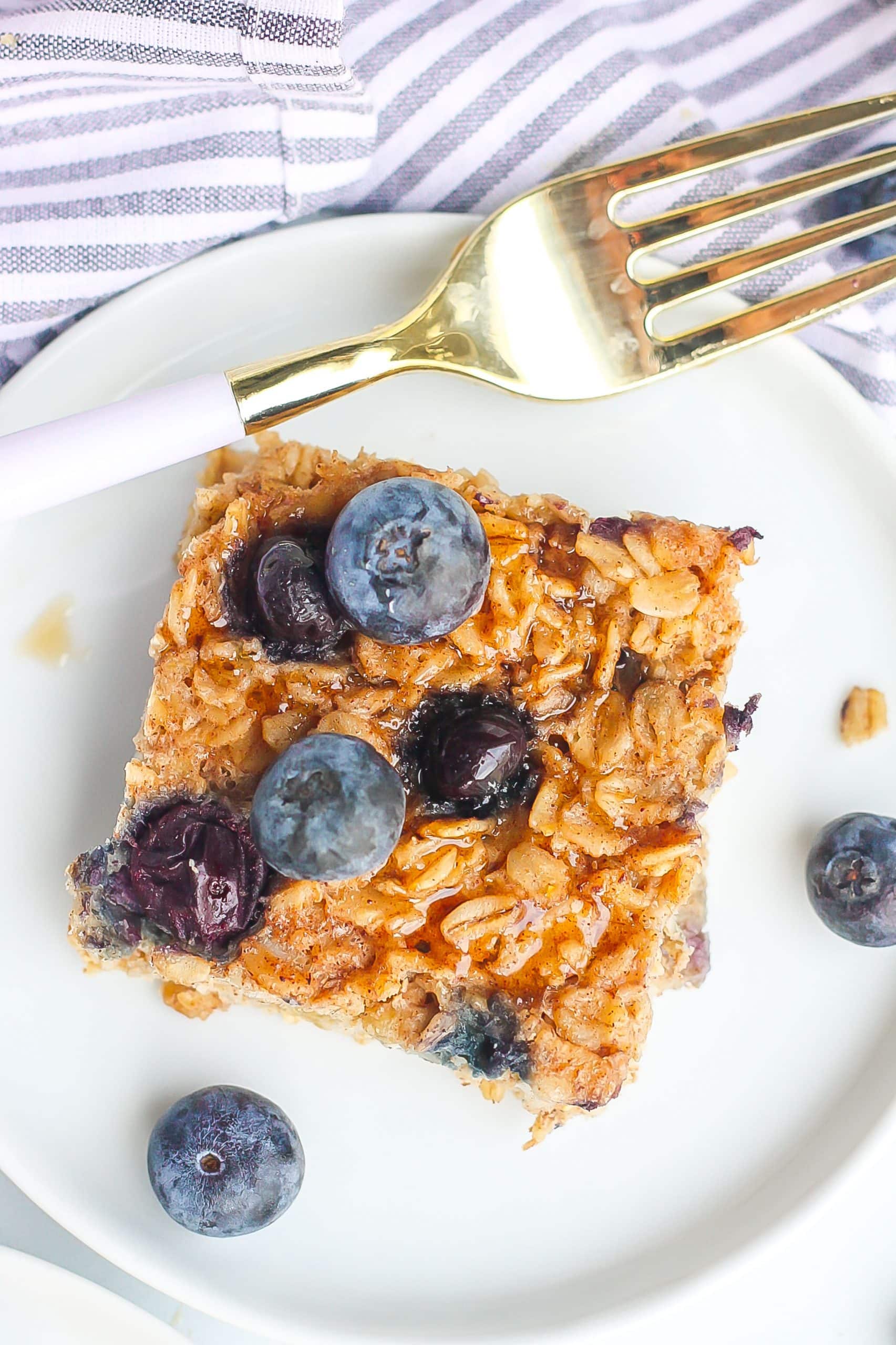 blueberry oatmeal square on white plate with fork