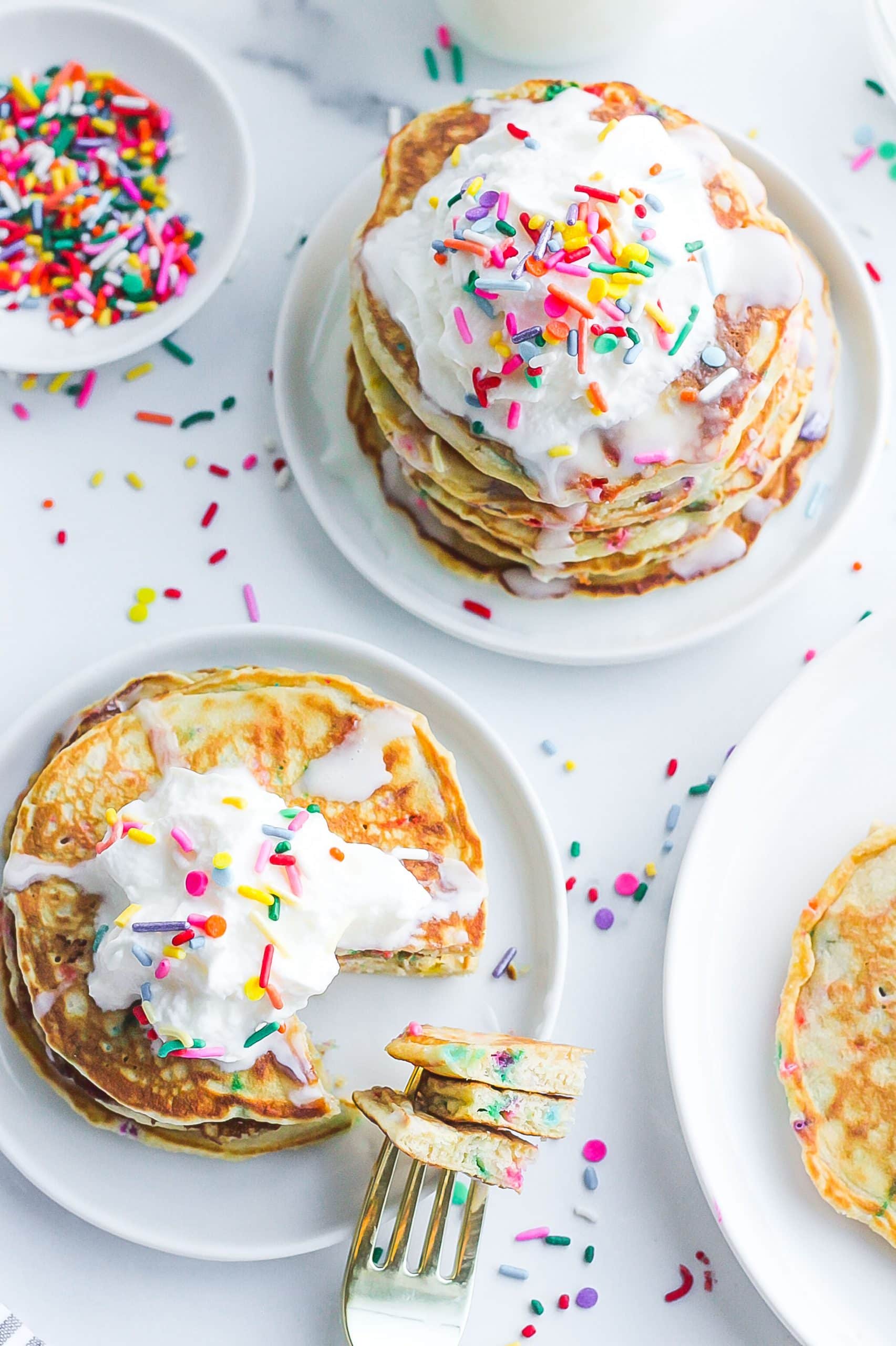 stacks of homemade funfetti pancakes on white plates
