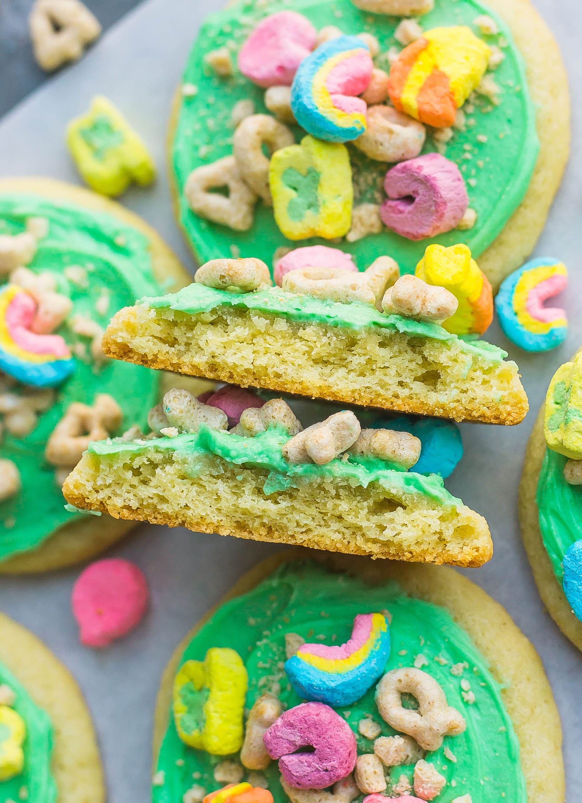 frosted sugar cookie split in half with lucky charms on top