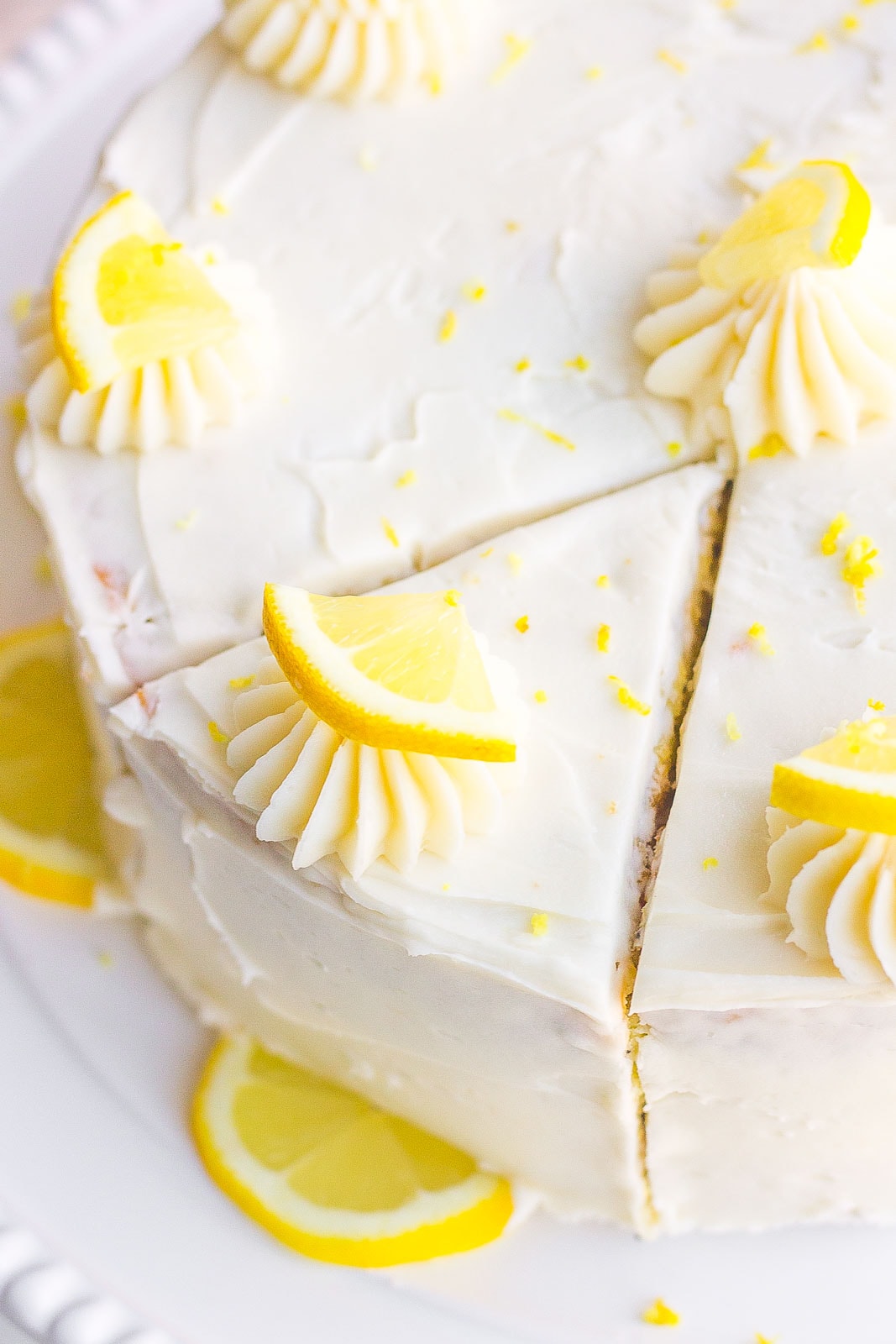 Frosted Lemon Poppy Seed Cake with a slice mark
