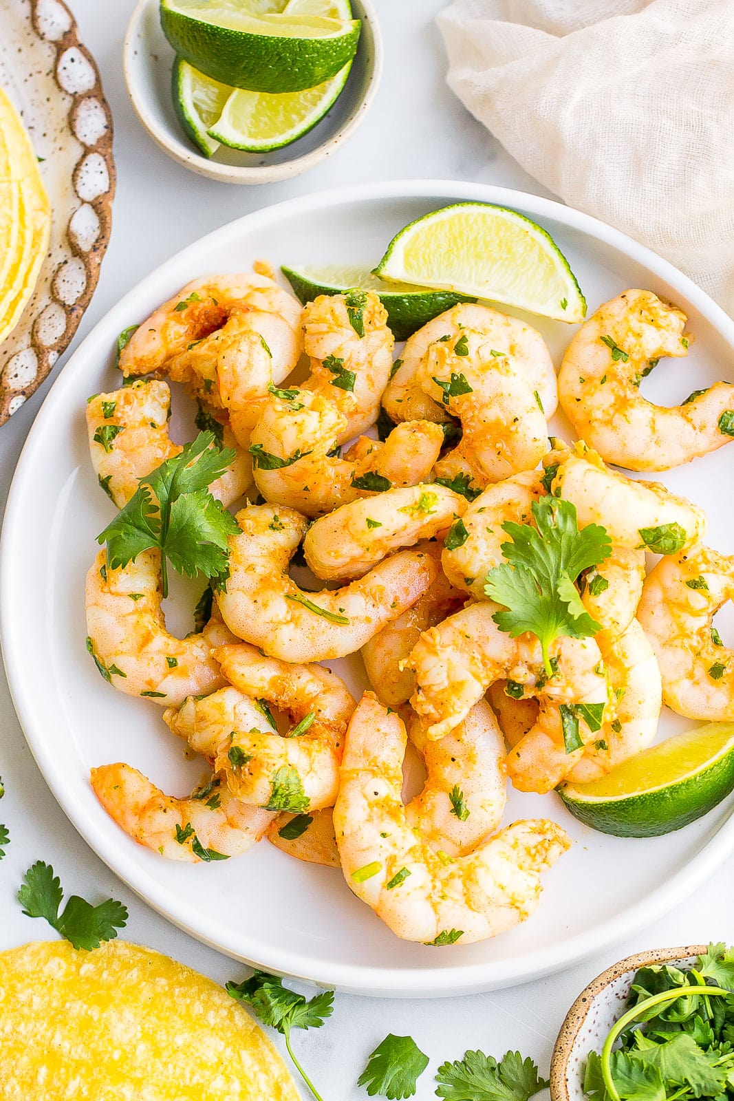 Quick and Easy Cilantro Lime Shrimp on a white plate with lime wedges