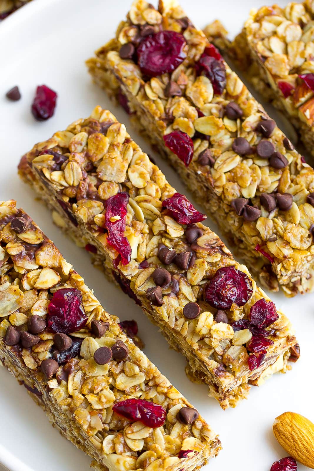 healthy granola bars on white plate with almonds, dried cranberries, and almonds