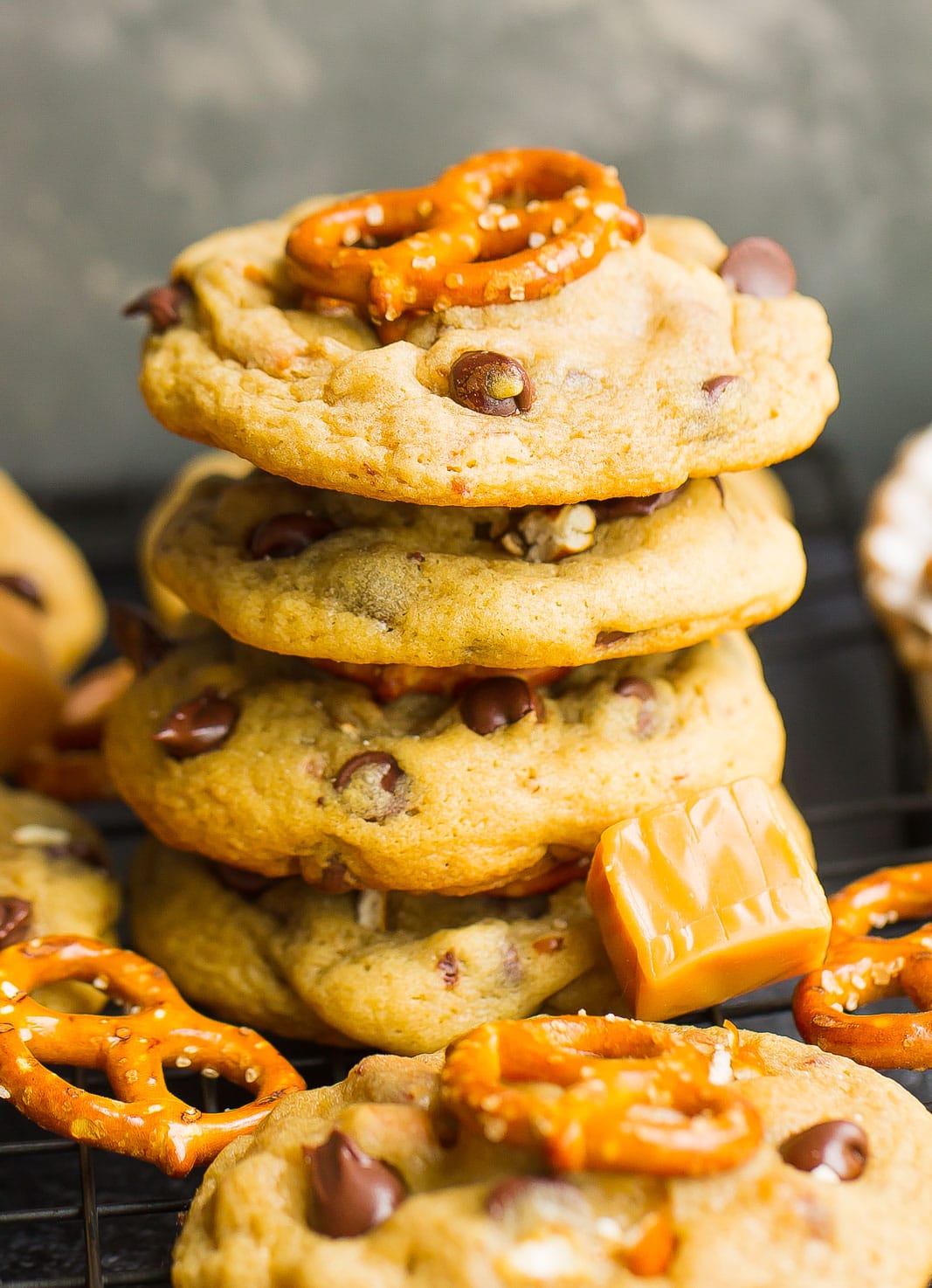 Tall stack of pretzel cookies on cooling rack.