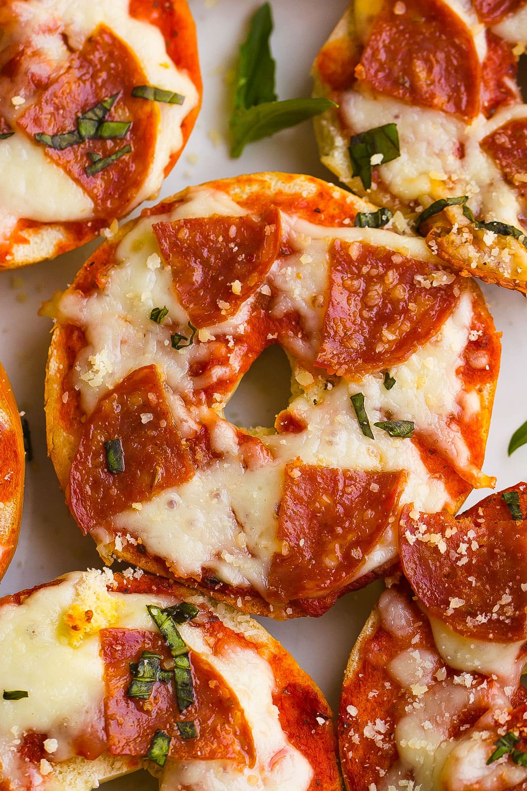 close up of mini pizza bagels with pepperoni and cheese