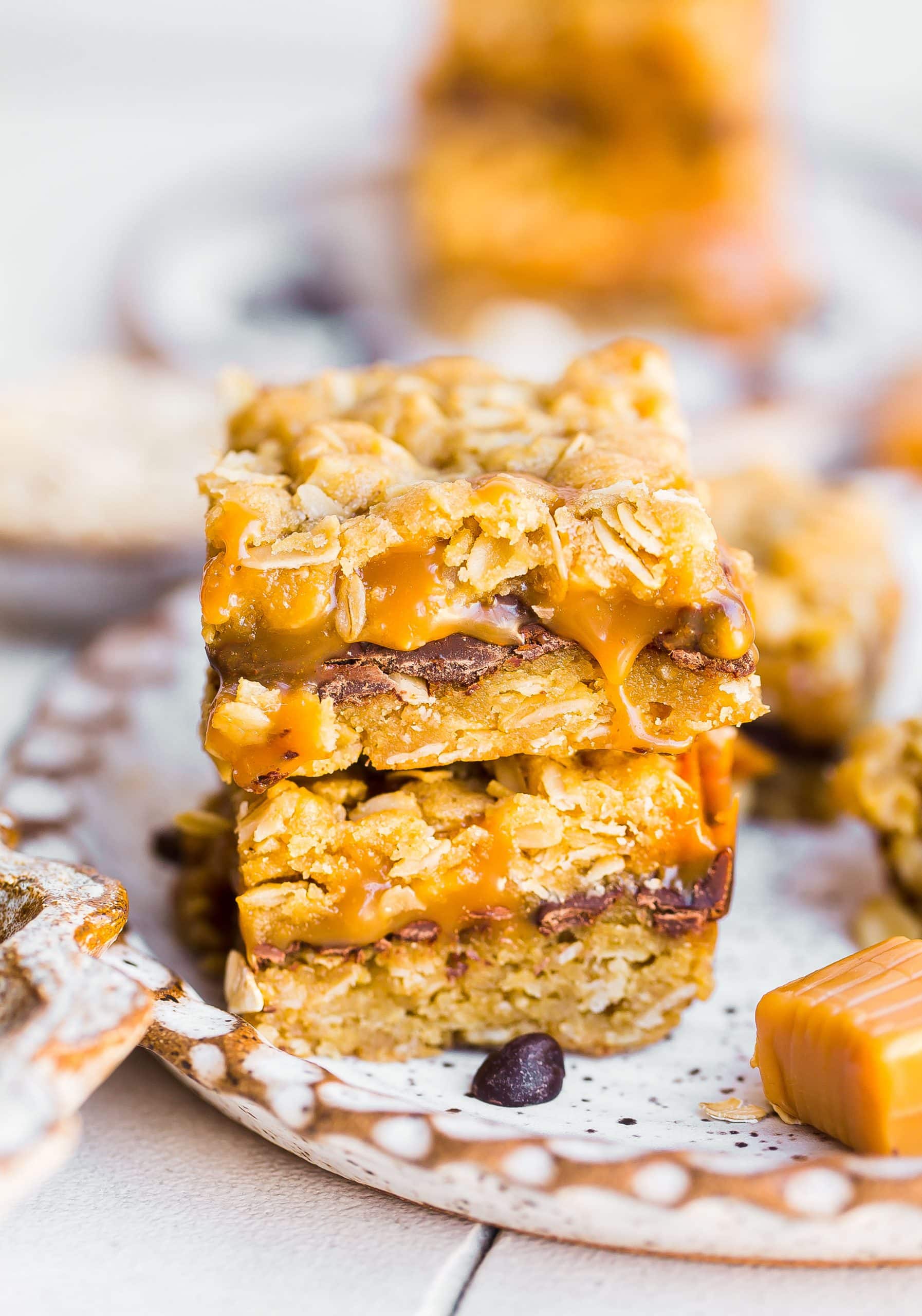Stack of Chocolate caramel oat bars with caramel oozing out. 
