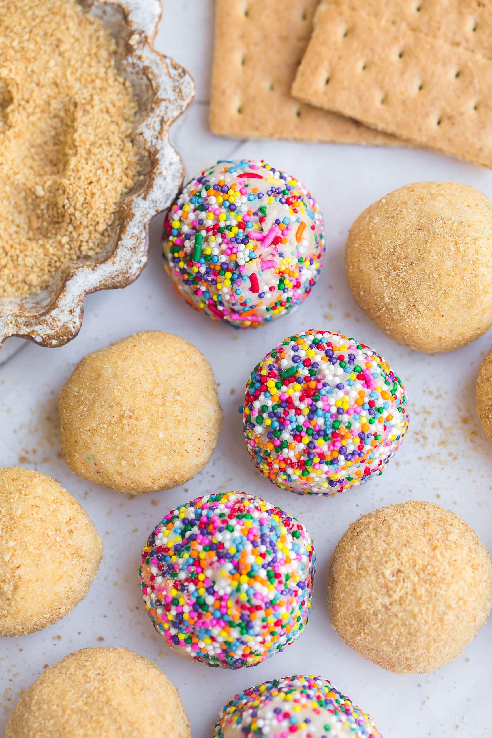 Cheesecake balls coated in sprinkles and graham crackers.