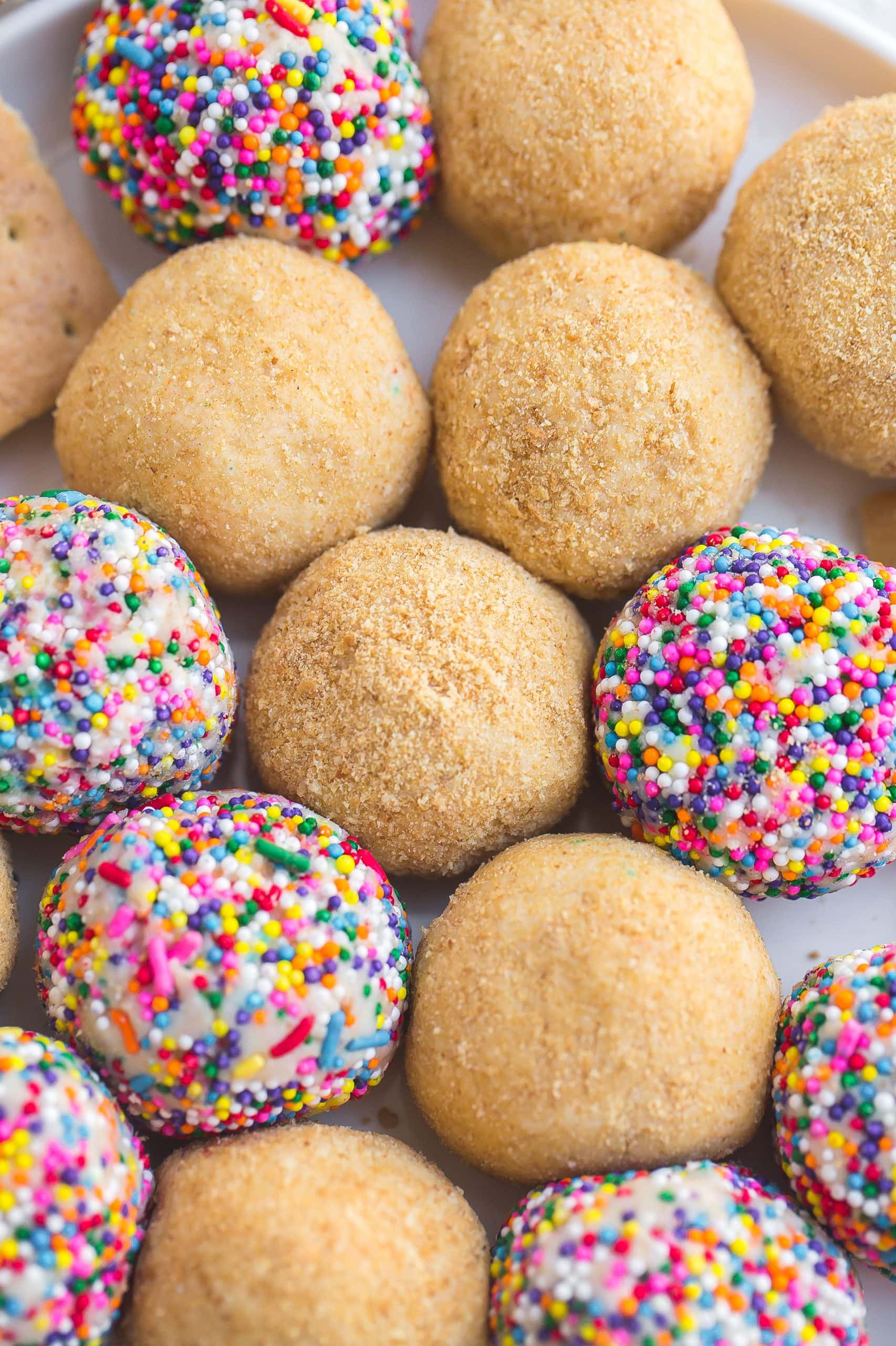Platter of cheesecake balls coated in graham cracker crumbs and sprinkles.