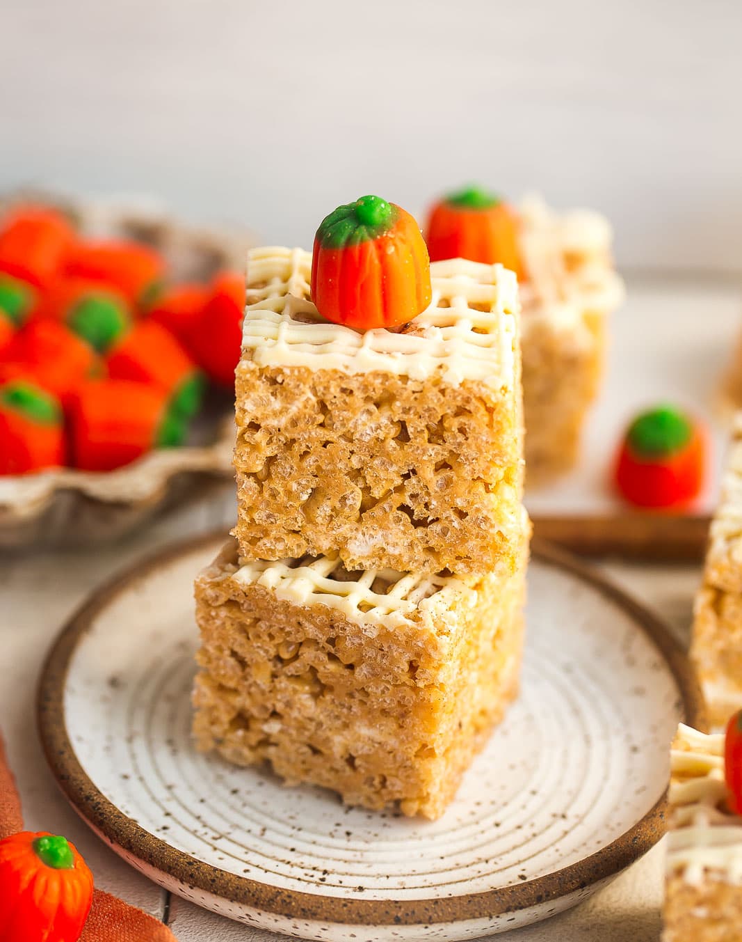 Pumpkin rice krispie treats stacked on a small plate. 