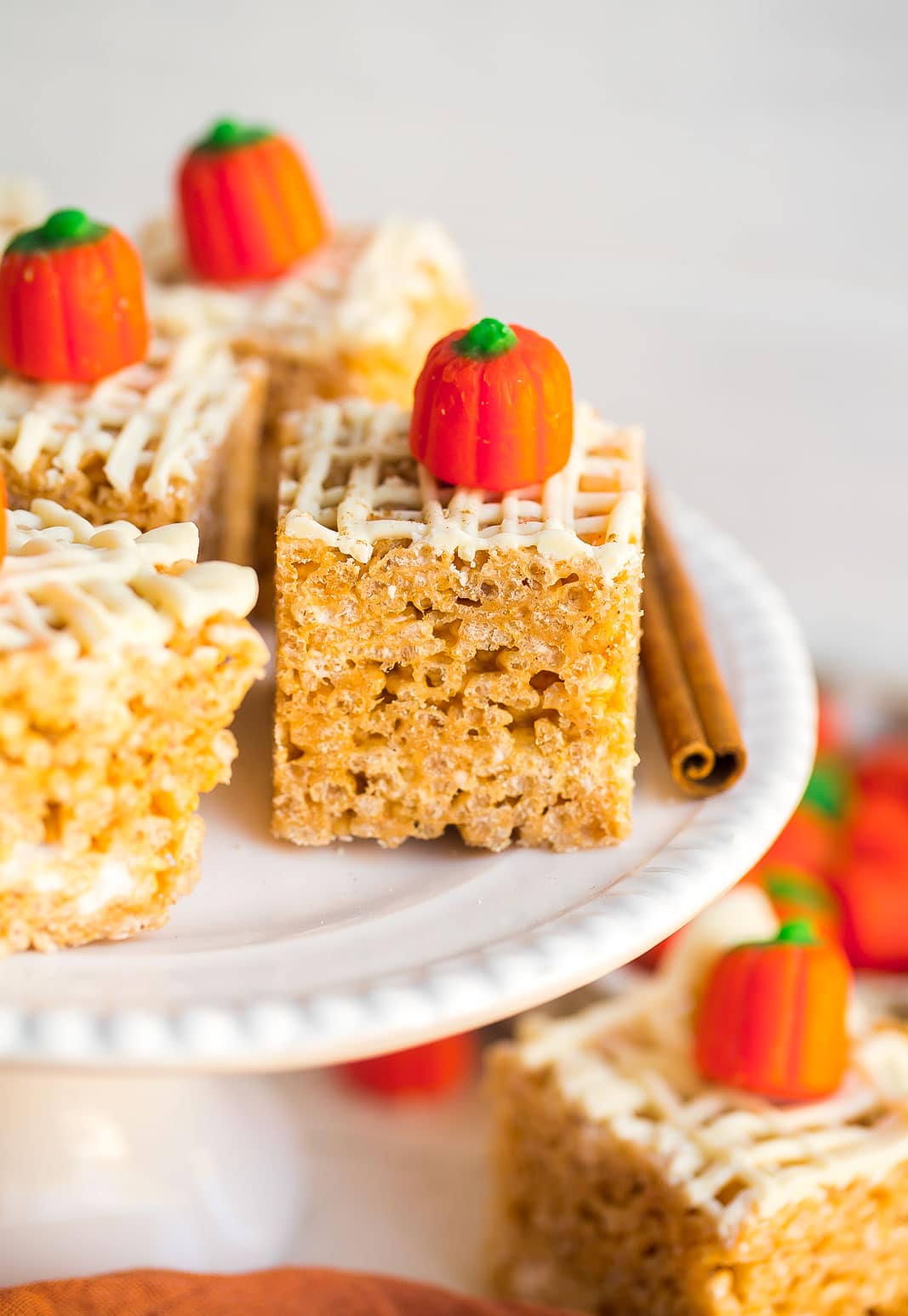 Close up of rice krispie treat on a white platter with a candy pumpkin.