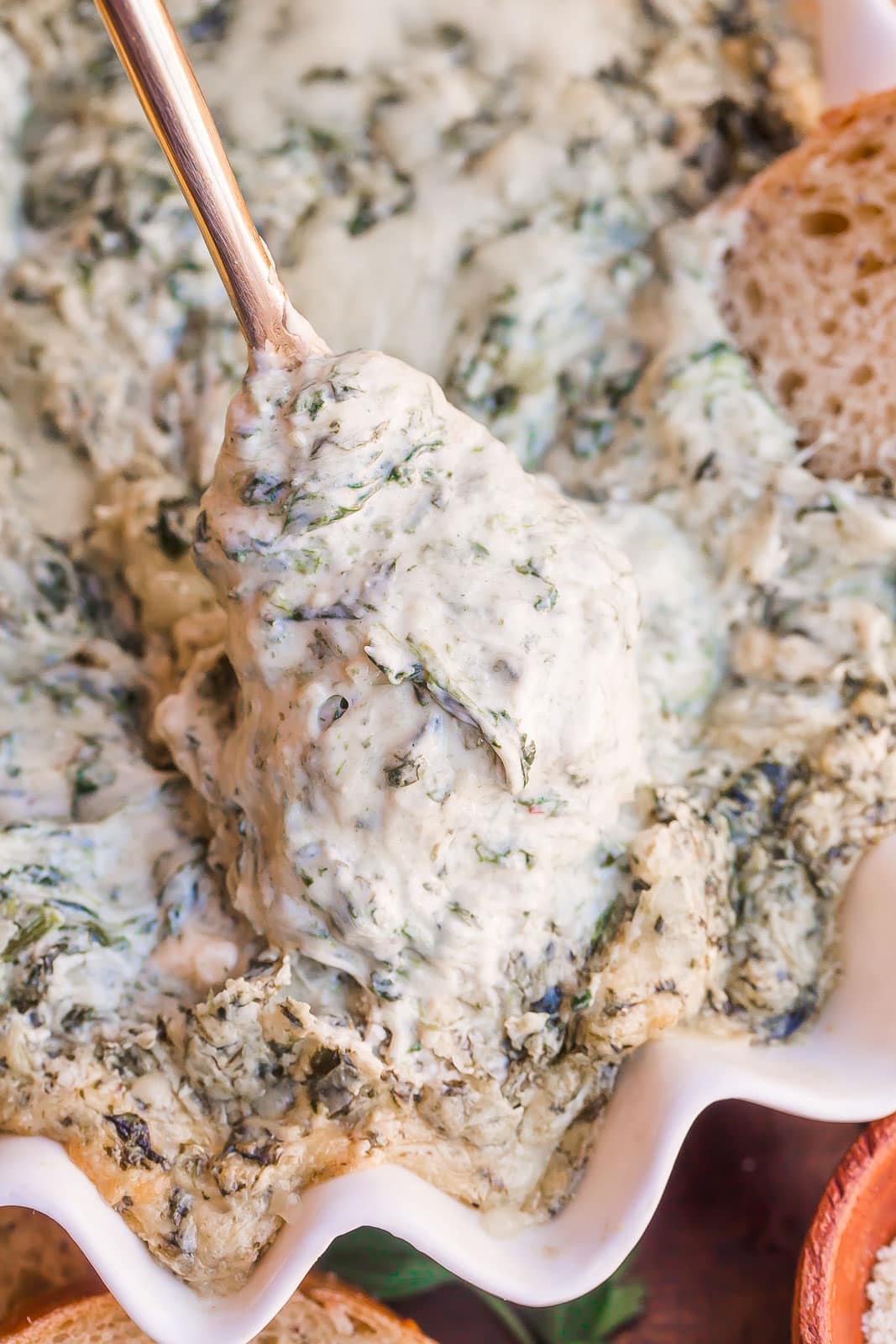 Cheesy spinach dip on a spoon.