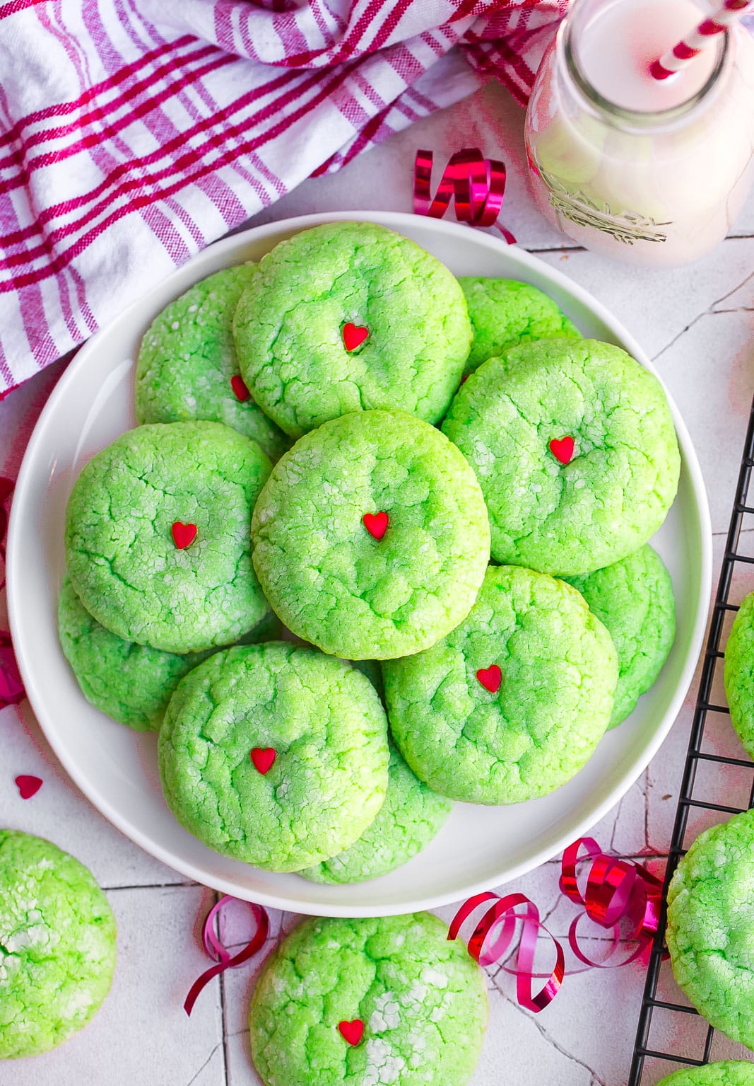 White plate full of Grinch Cookies with red curled ribbon.