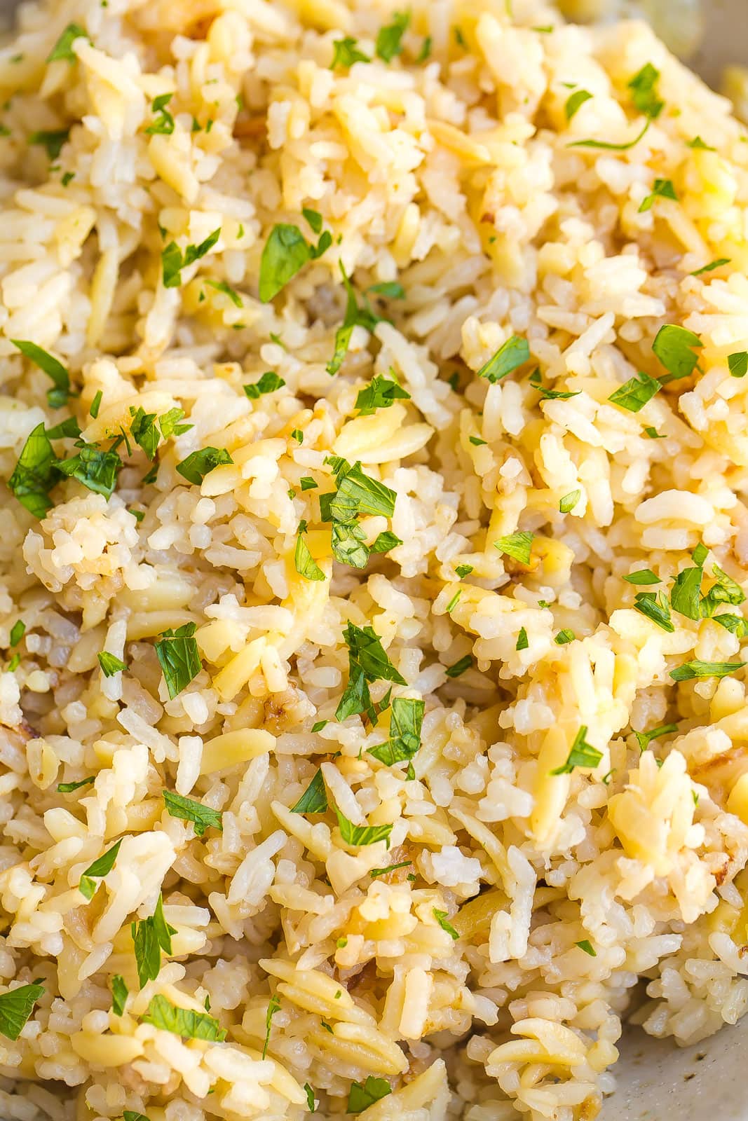 Closeup view of rice pilaf with chopped parsley on top.