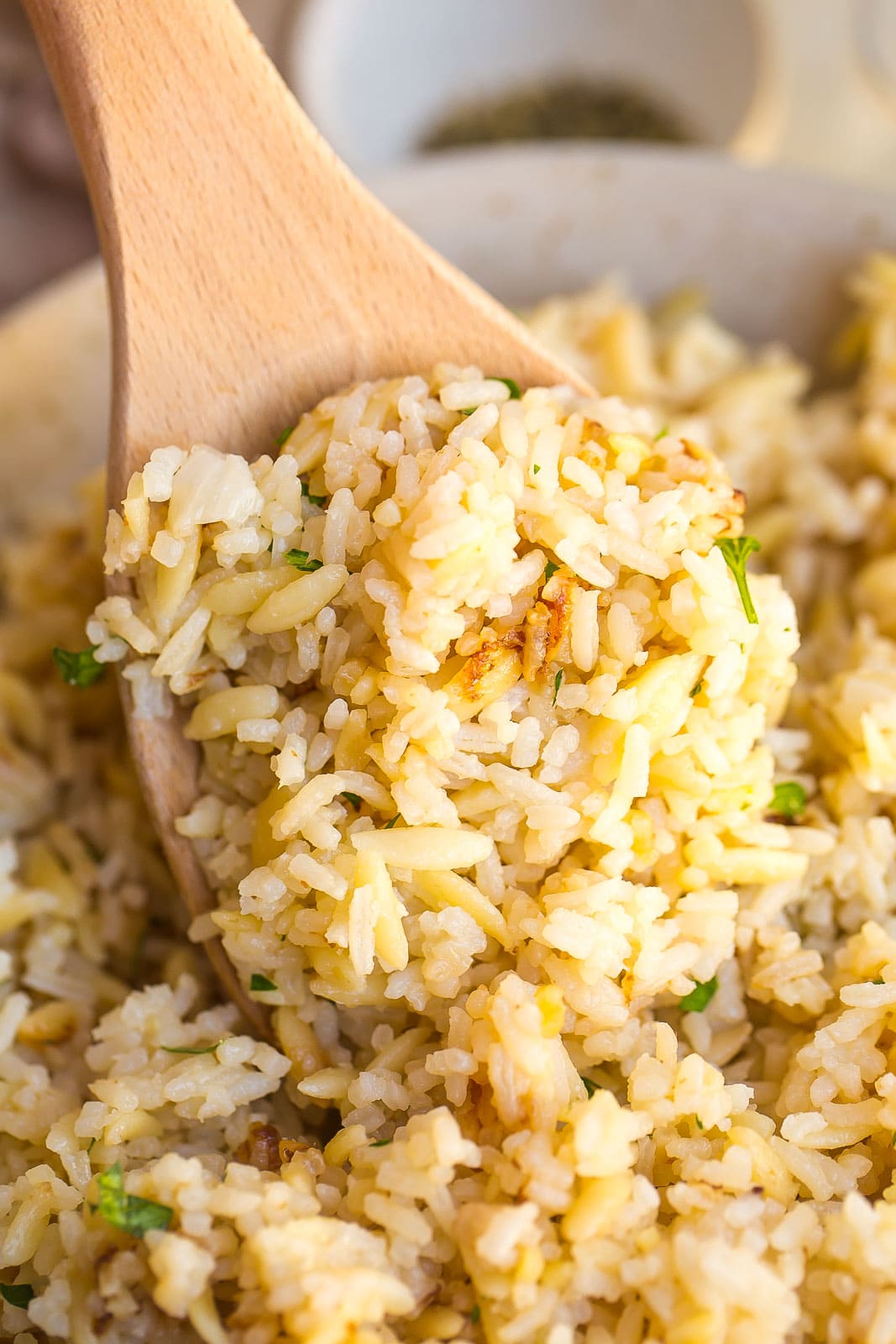 Rice pilaf on a wooden serving spoon.