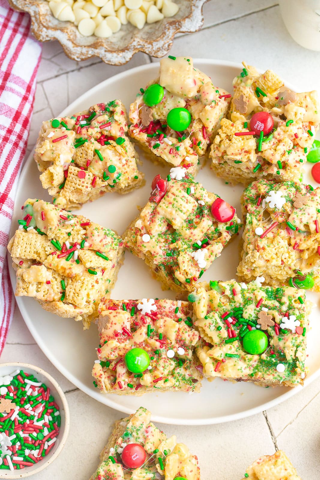 White plate of rice krispie treats with Christmas sprinkles.