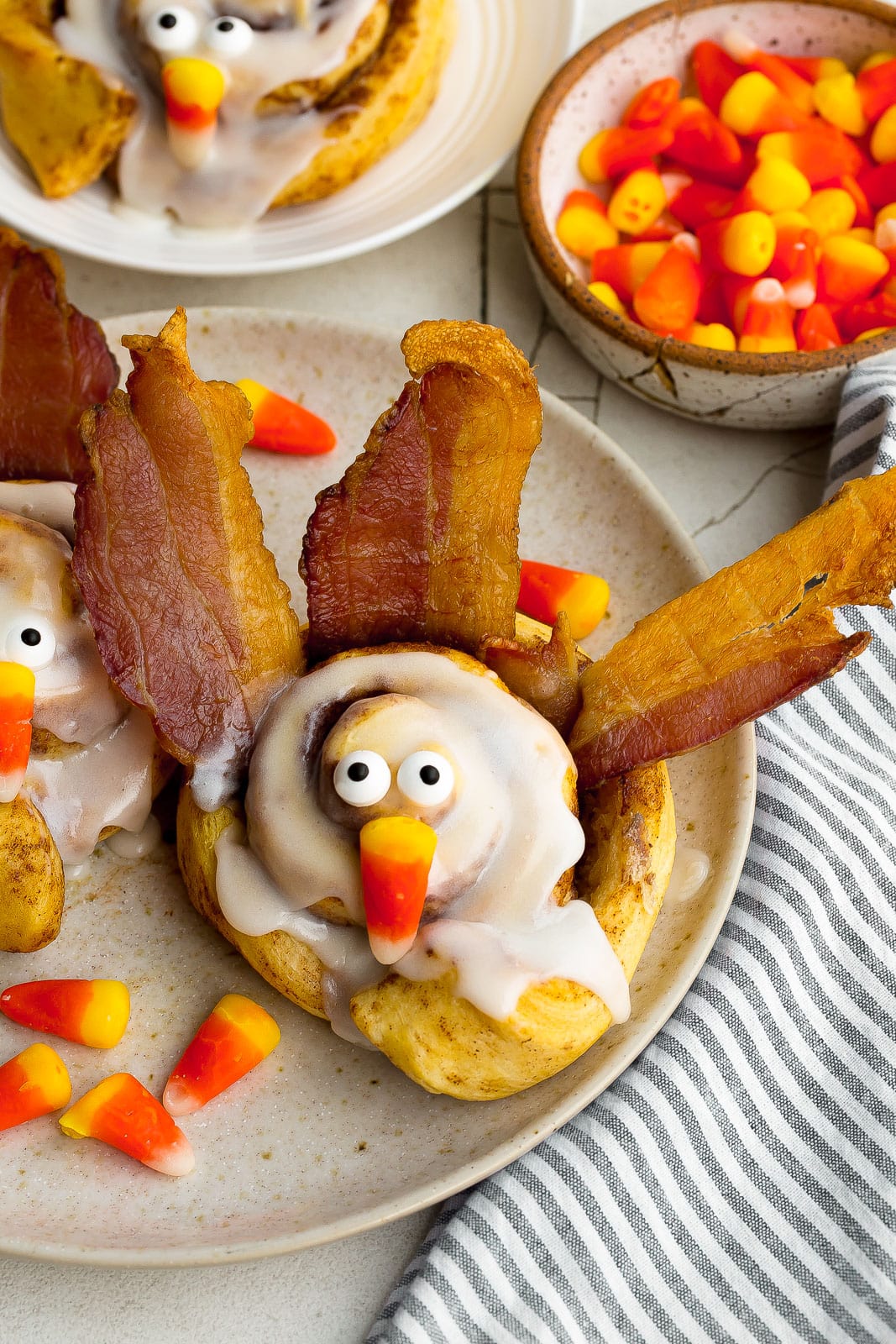 Plate with cinnamon rolls, bacon, candy corn, and edible eyes.