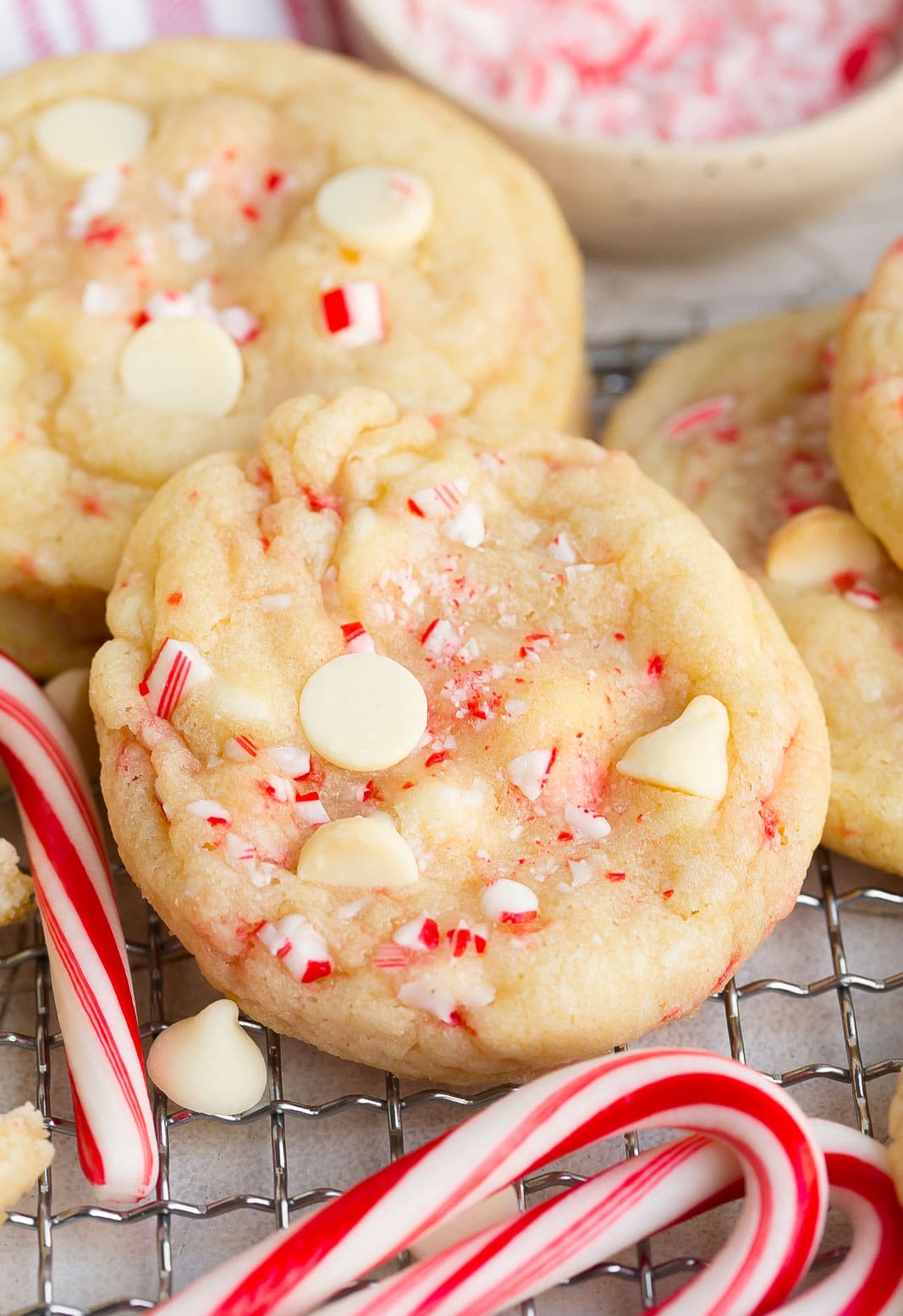 White Chocolate Peppermint Cookie on a cooling rack with a candy cane.