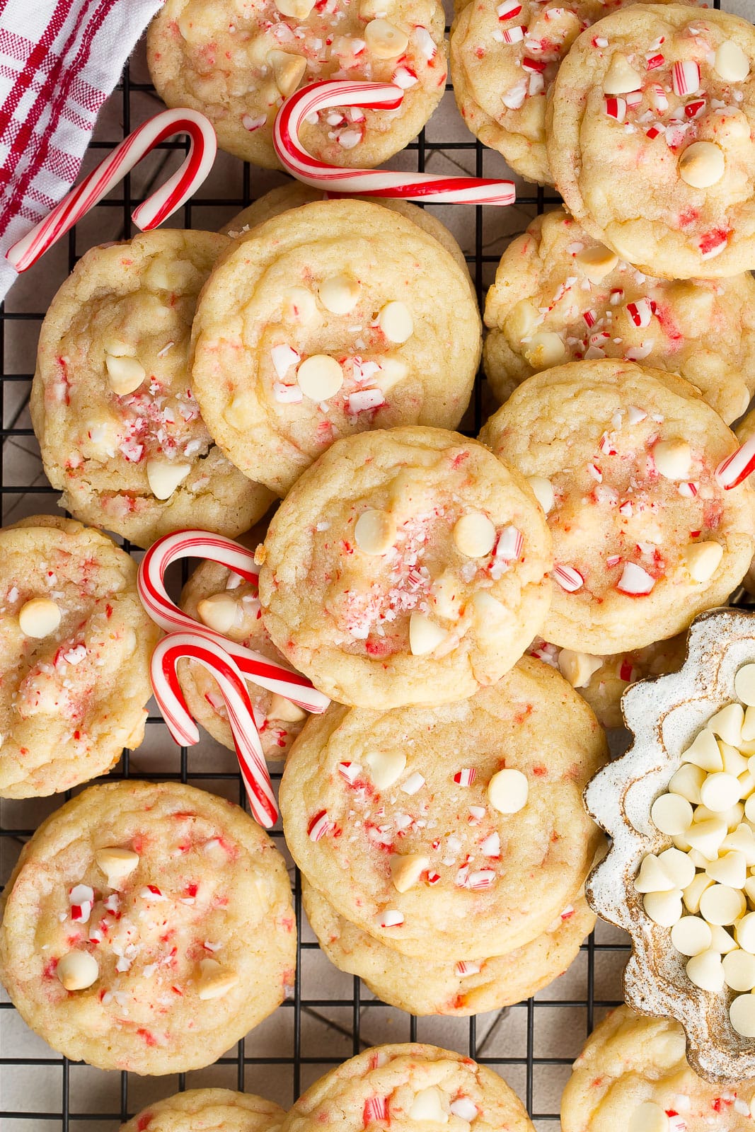 White chocolate cookies on a cooling rack with candy canes.