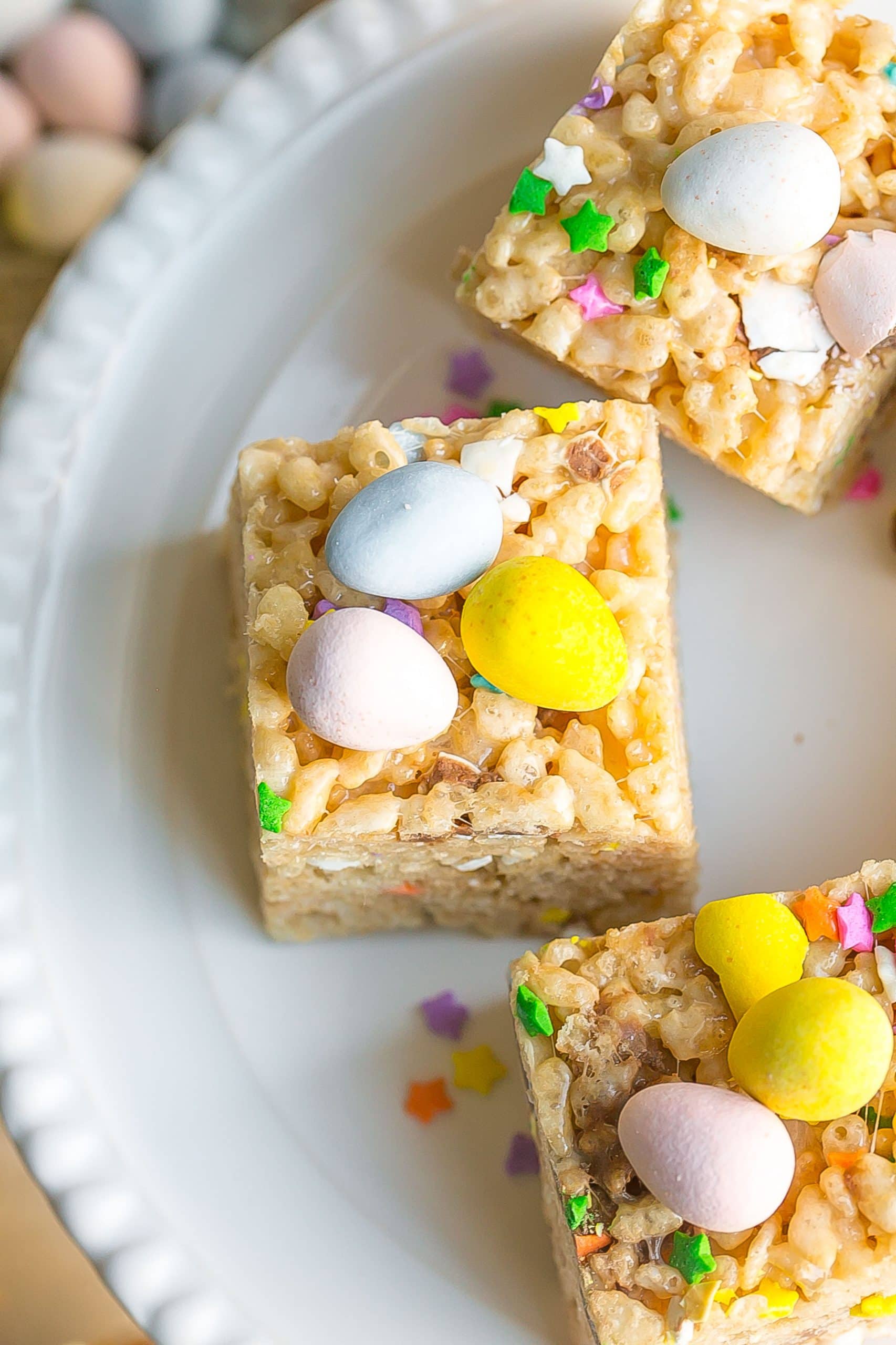 Birds eye view of rice krispie treats with chocolate egg candies on top.