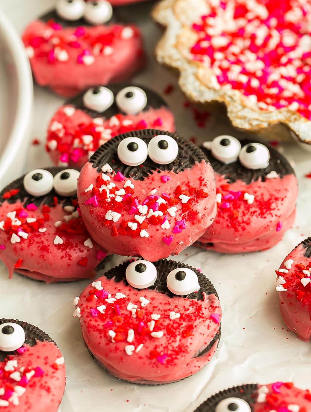 Valentine's Day Oreos Love Bugs on a white plate with sprinkles.