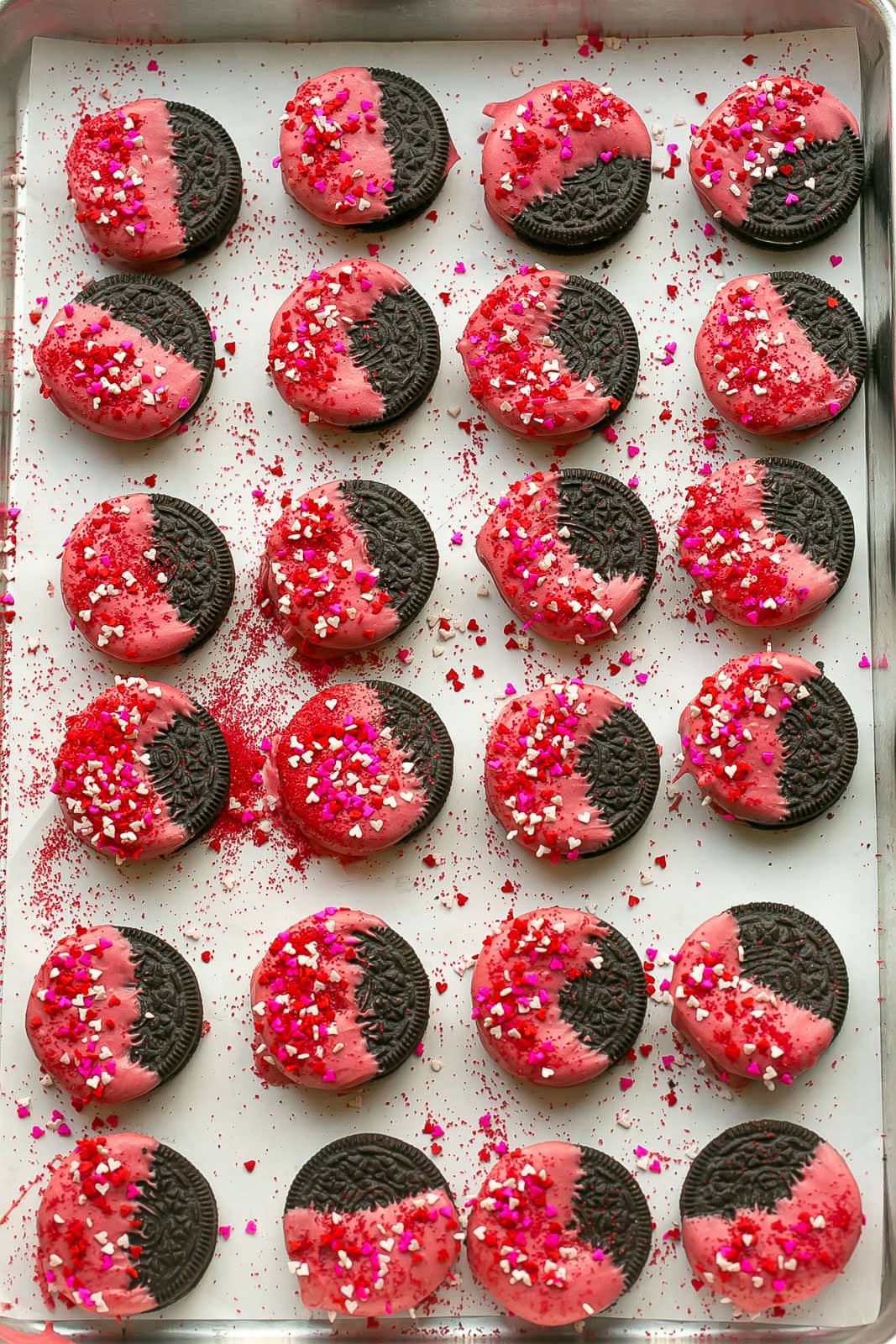 Valentine's Day Oreos decorated into Love Bugs on a baking sheet.
