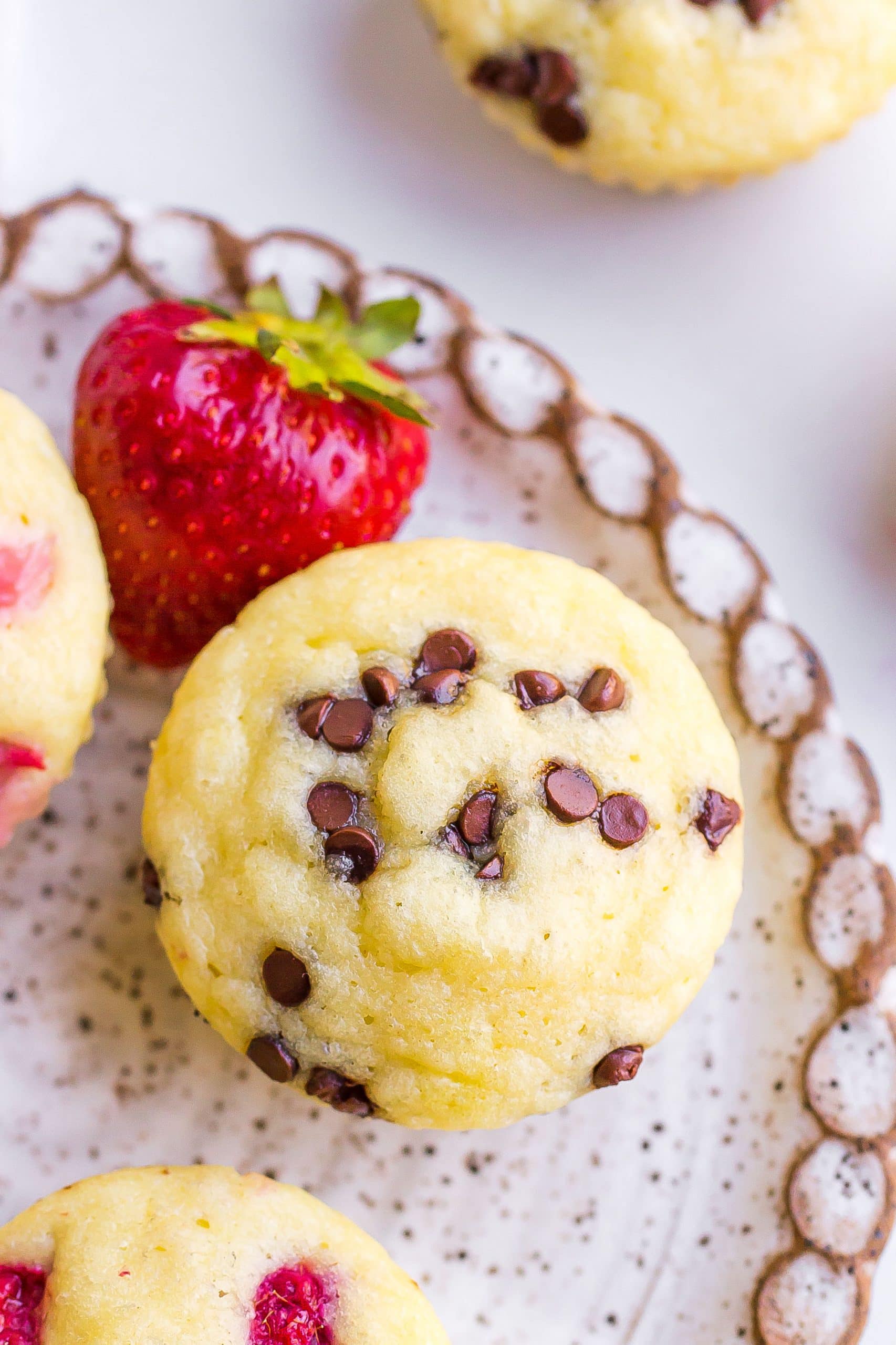 Close up of a pancake muffin with chocolate chips and a fresh strawberry.