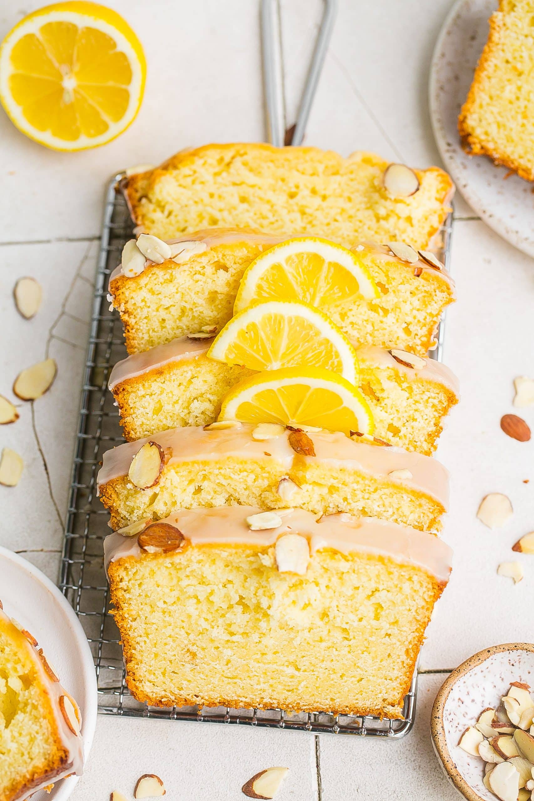 Almond Loaf Cake slices with sliced lemons on top. 